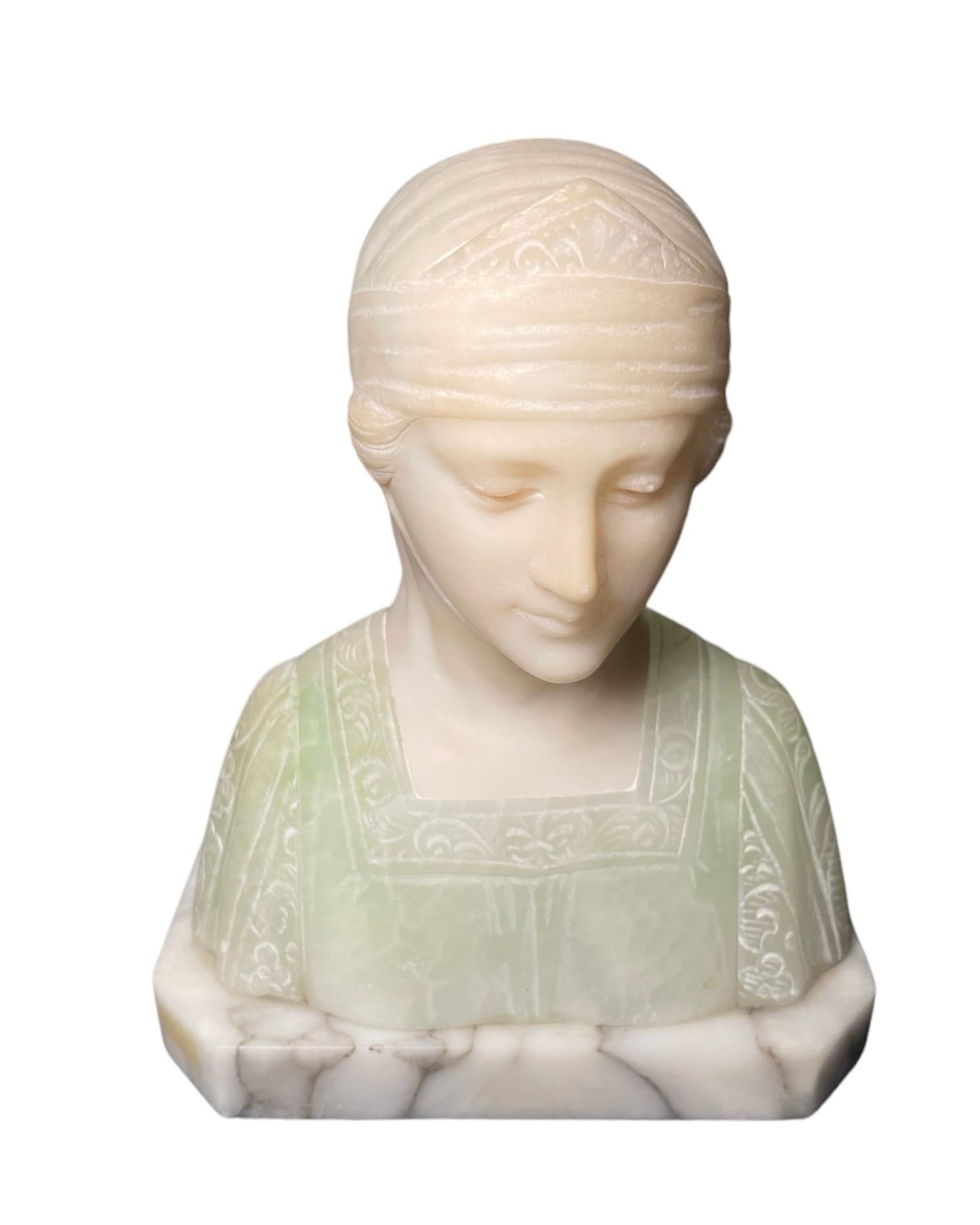 This is a marble and alabaster bust of Beatrice. It depicts a small, but heavy bust of an Italian lady dressed with a Renaissance style costumes. The dress is mint green (it symbolizes Hope) with some carved details in the square collar and the