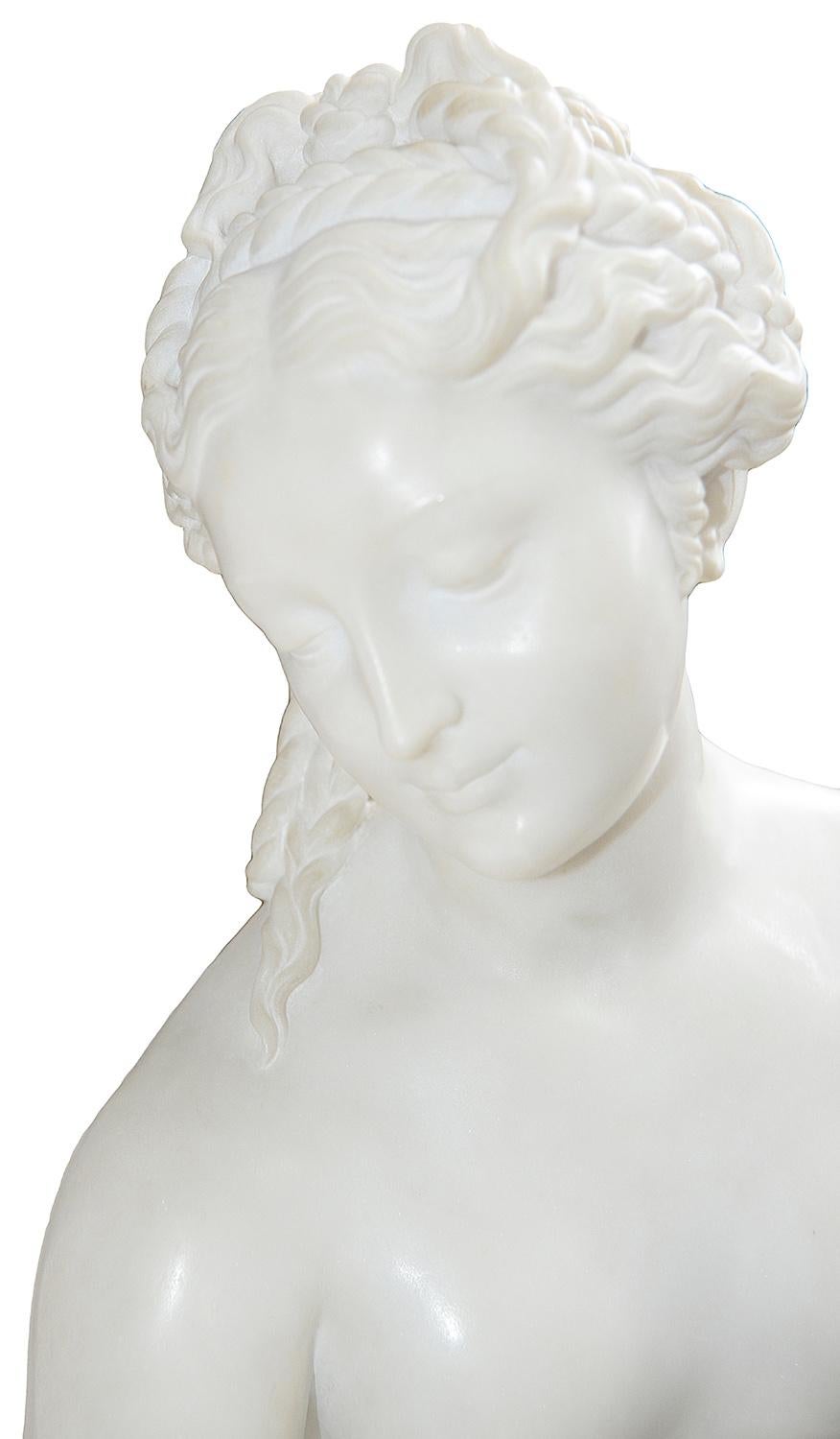 A fine quality early 20th century Carrera marble statue of 'Venus Au Bain' being semi nude with drapers around her and raised on a plinth base. Measures: 165cm (65