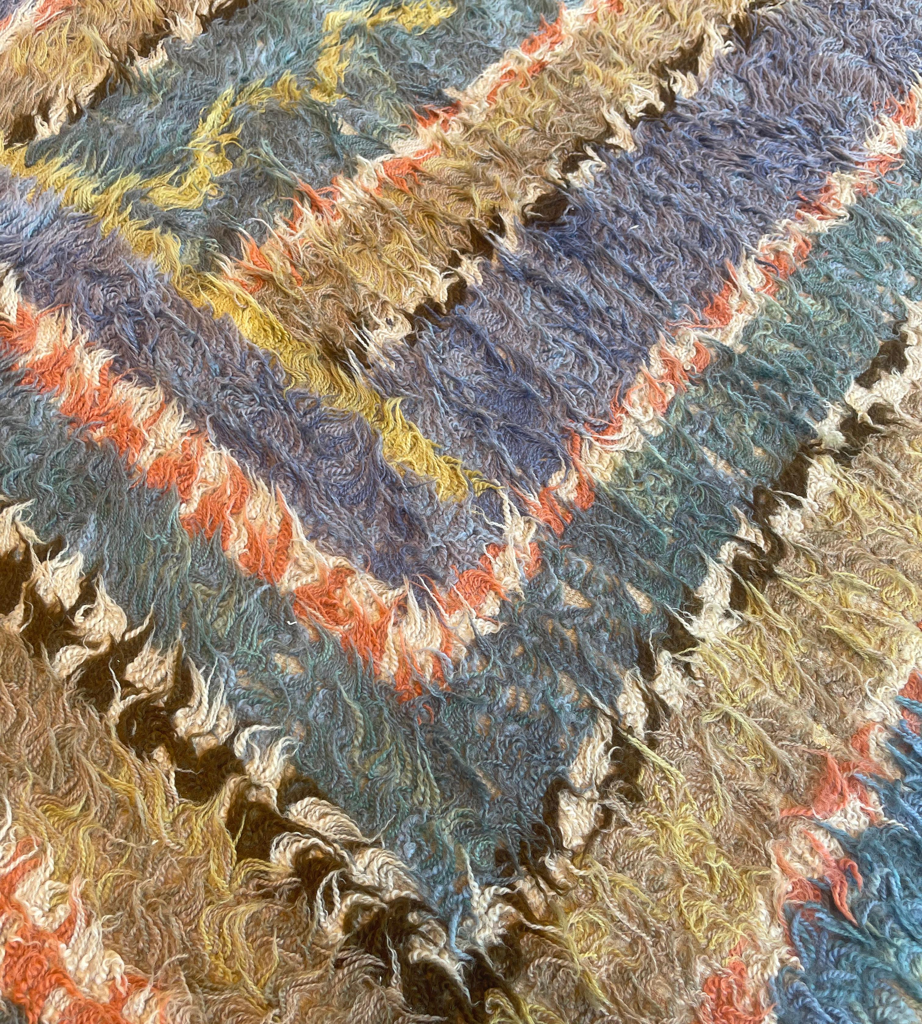 Dieser handgewebte schwedische Deco-Teppich im Vintage-Stil hat ein polychromes Feld aus konzentrischen, skurrilen, komplementären geometrischen Feldern, die durch schwungvolle geometrische Streifen getrennt sind. Signiert vom
