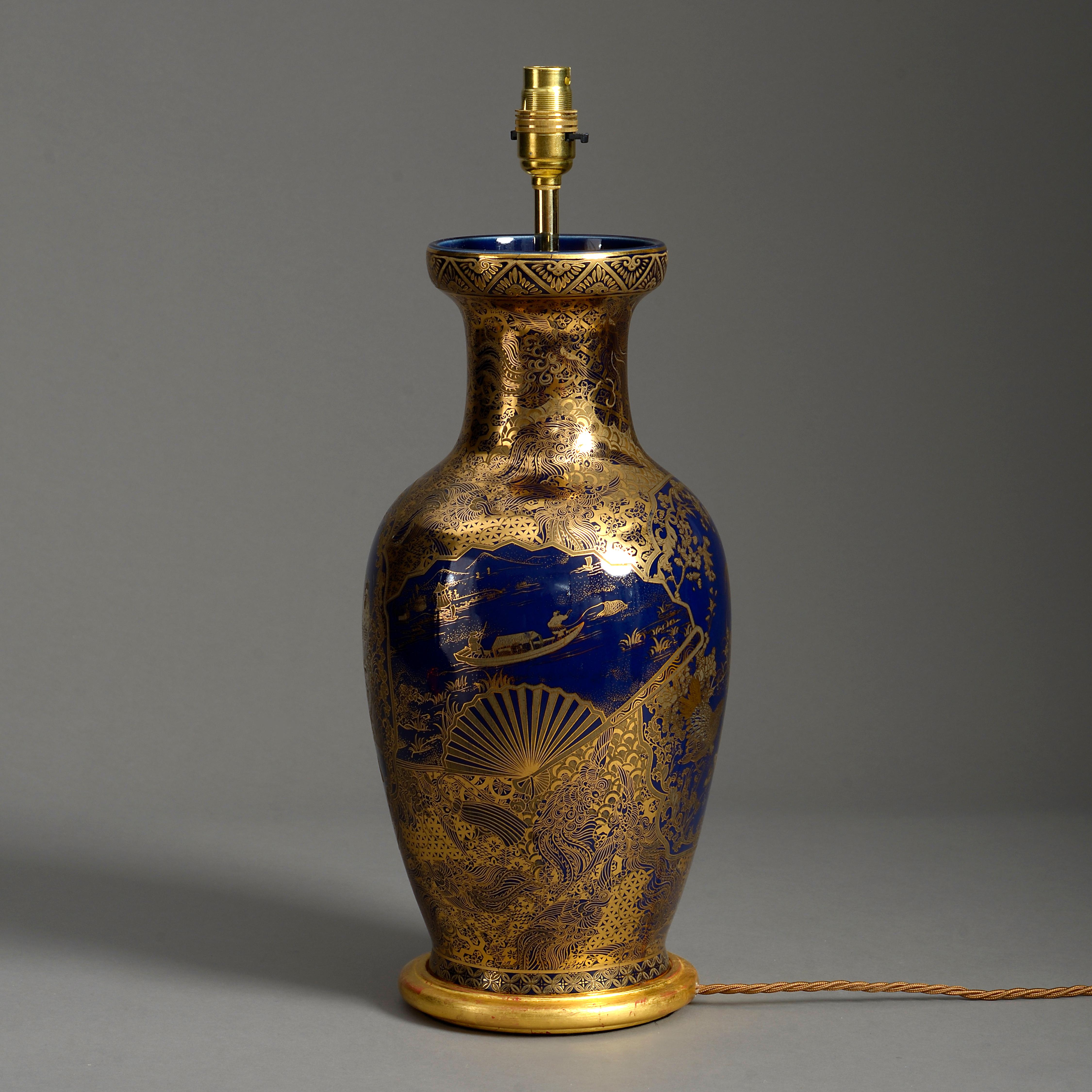 An early twentieth century baluster vase, decorated throughout with gilded fans, river scenes, birds, fish scales and other stylised emblems associated with Kimono designs. Now mounted on a hand-turned giltwood base as a lamp for electric