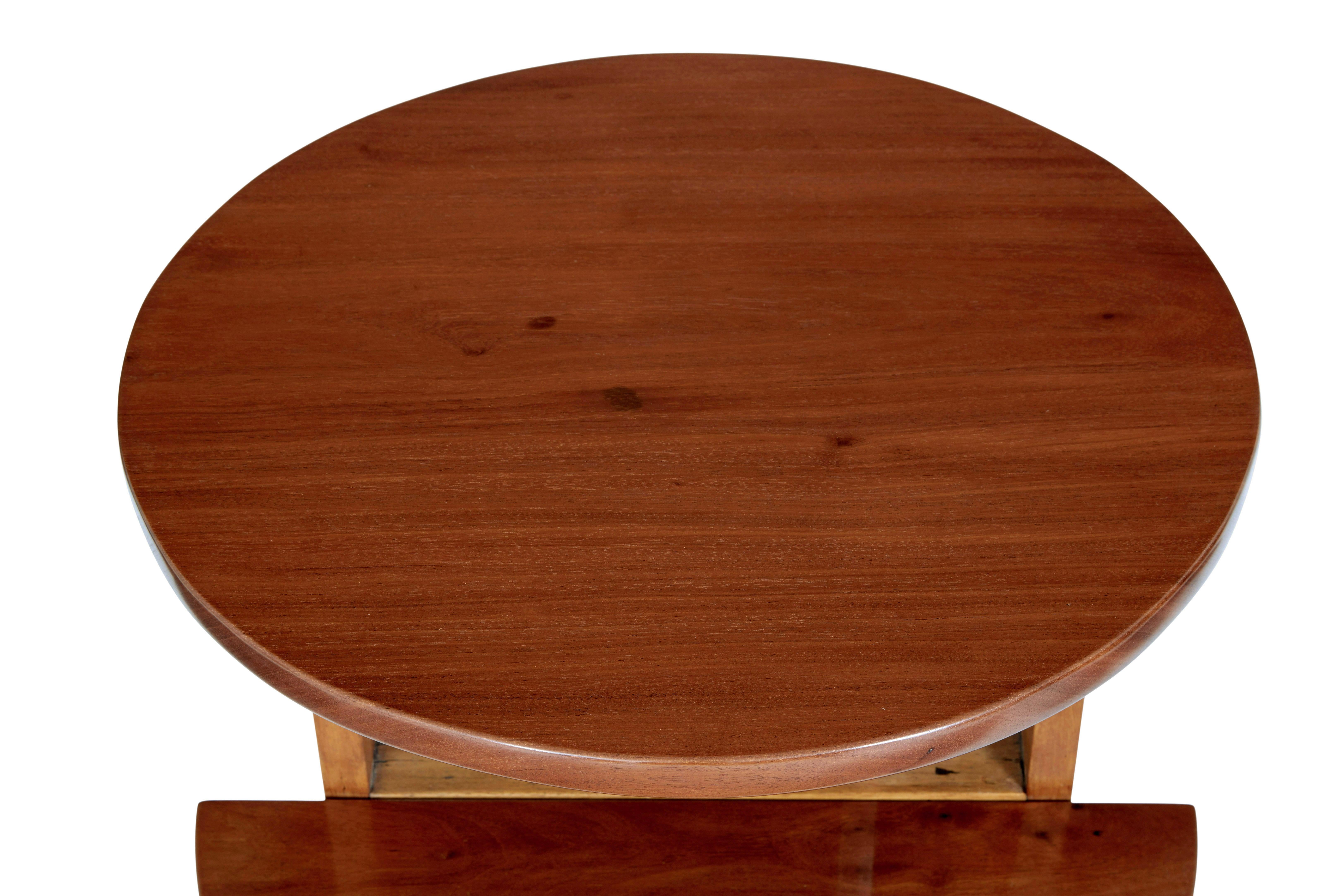Early 20th century metamorphic mahogany occasional table circa 1920.

Well designed piece of furniture from the 1920's that has multiple uses around the home.  Comprising of 2 tiers, a full round solid mahogany top surface and a half circle tier of