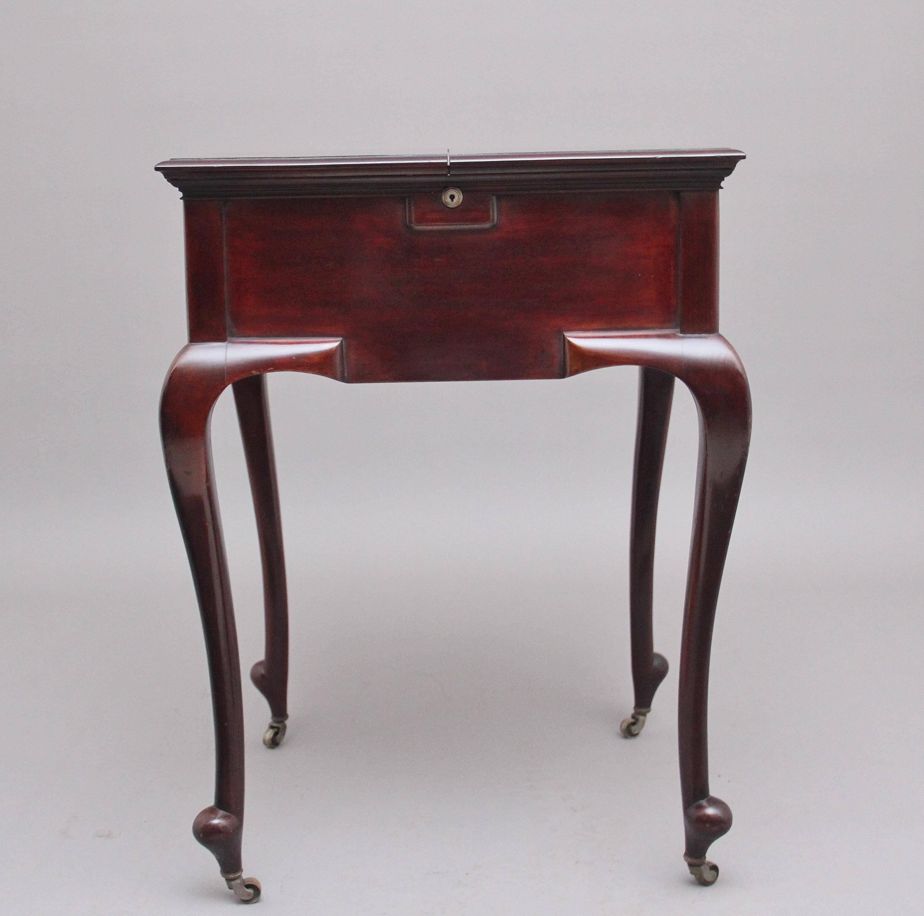 Early 20th century mahogany metamorphic writing table by J.C Vickery of Regent St, London, the moulded edge hinged top lifting up and folding over to reveal the rising writing desk top, which consists of various writing instruments including ink