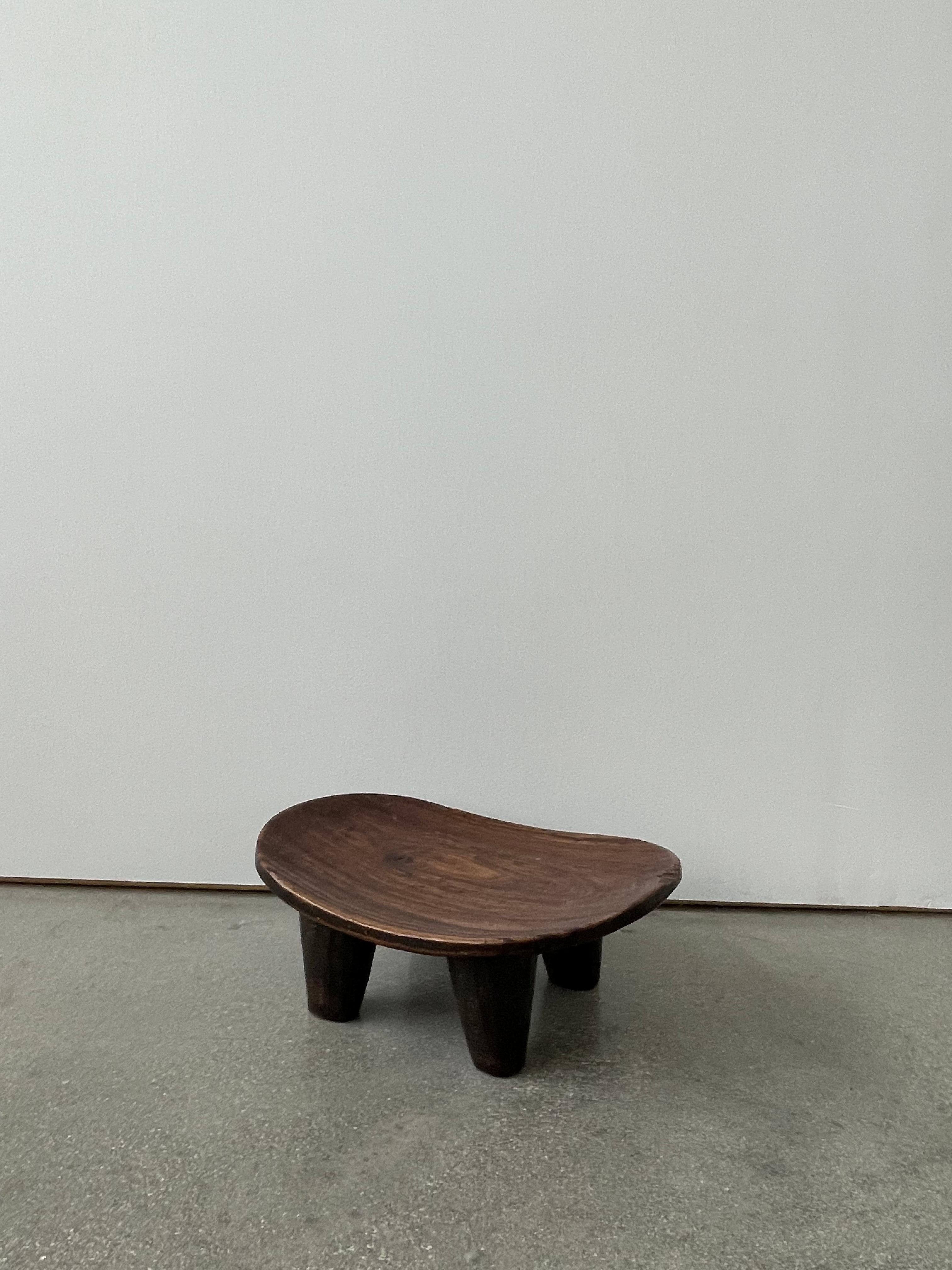 Early 20th Century Mini Wooden Senufo stool was hand-carved from a single, solid block of wood, each Senufo stool retains a unique personality as a modern sculpture, seat, or table. The slightly lifted seat combines with the stout legs to create