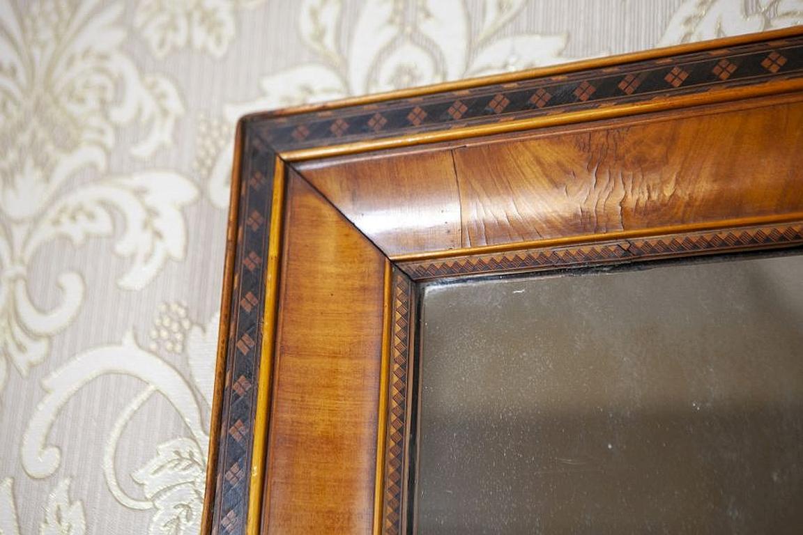 Early-20th century mirror in frame veneered with walnut.

We present you this mirror from the early 20th century in a coniferous wood frame veneered with walnut.
The wooden frame is inlaid with a fillet line with geometrical