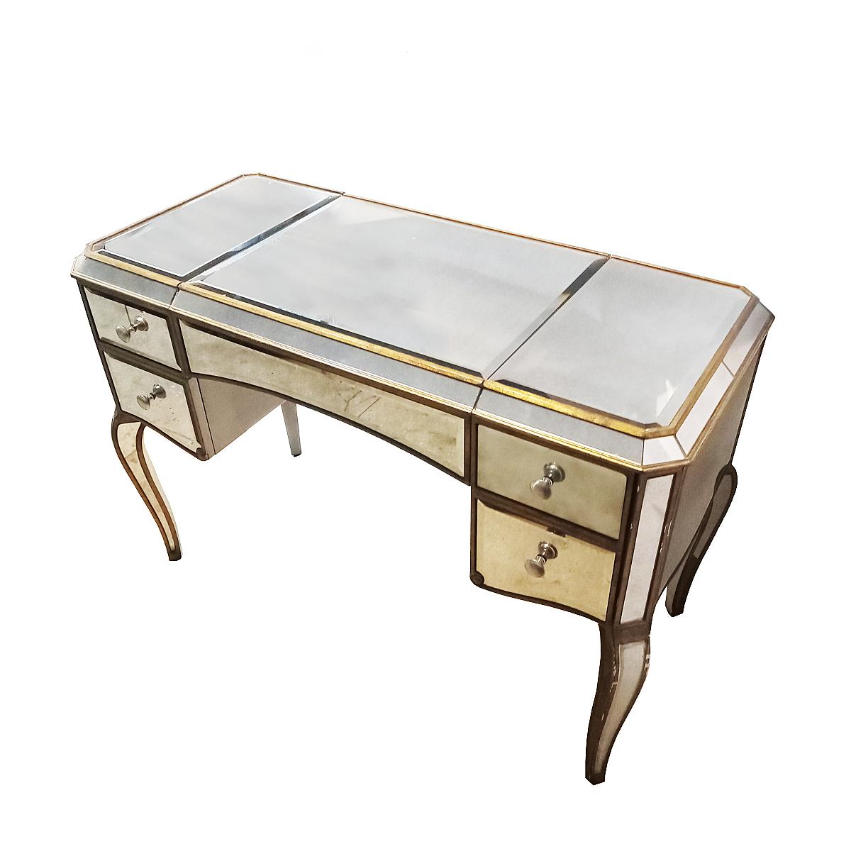A mirrored dressing table, Mid-Century modern, circa 1960. Giltwood accents, turned legs and 3 drawers, one on the right and two small ones on the left. The top surface opens to reveal 3  storage compartments and an additional mirror. 

Good, stable