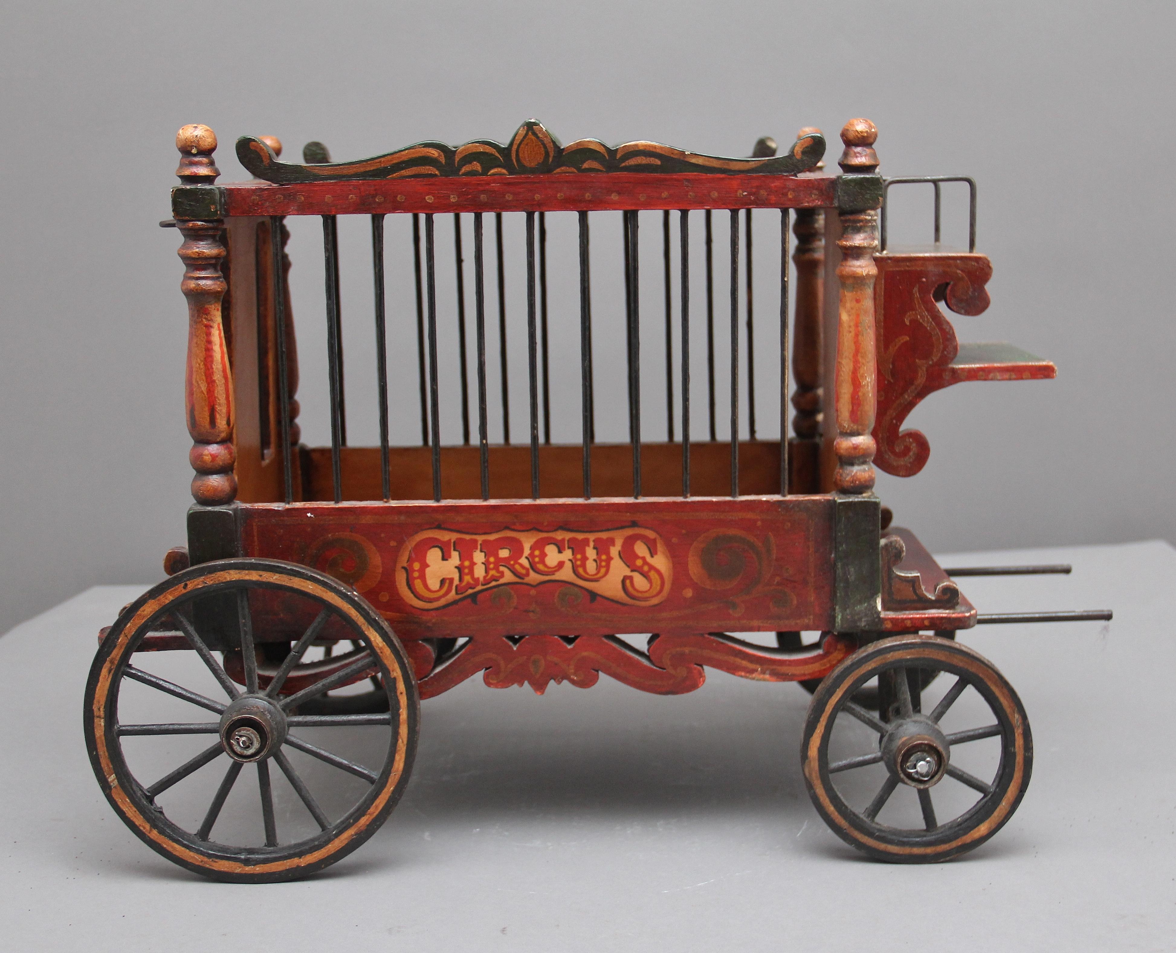 Early 20th century model of a circus wagon, the model itself is in the typical style of a circus wagon of that period with smaller wheels at the front and larger ones at the back, bars on all sides and the back section dropping down so the various