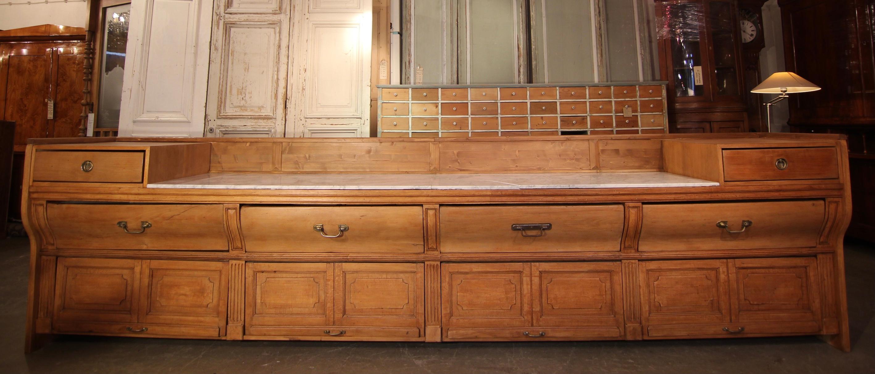 Elegant huge French boulangerie counter or goods display sideboard. Originally from the early 20th century with later additions. 

On rectangular ground plan standing long half-height beech wood corpus with Carrara marble top.

Vertically curved