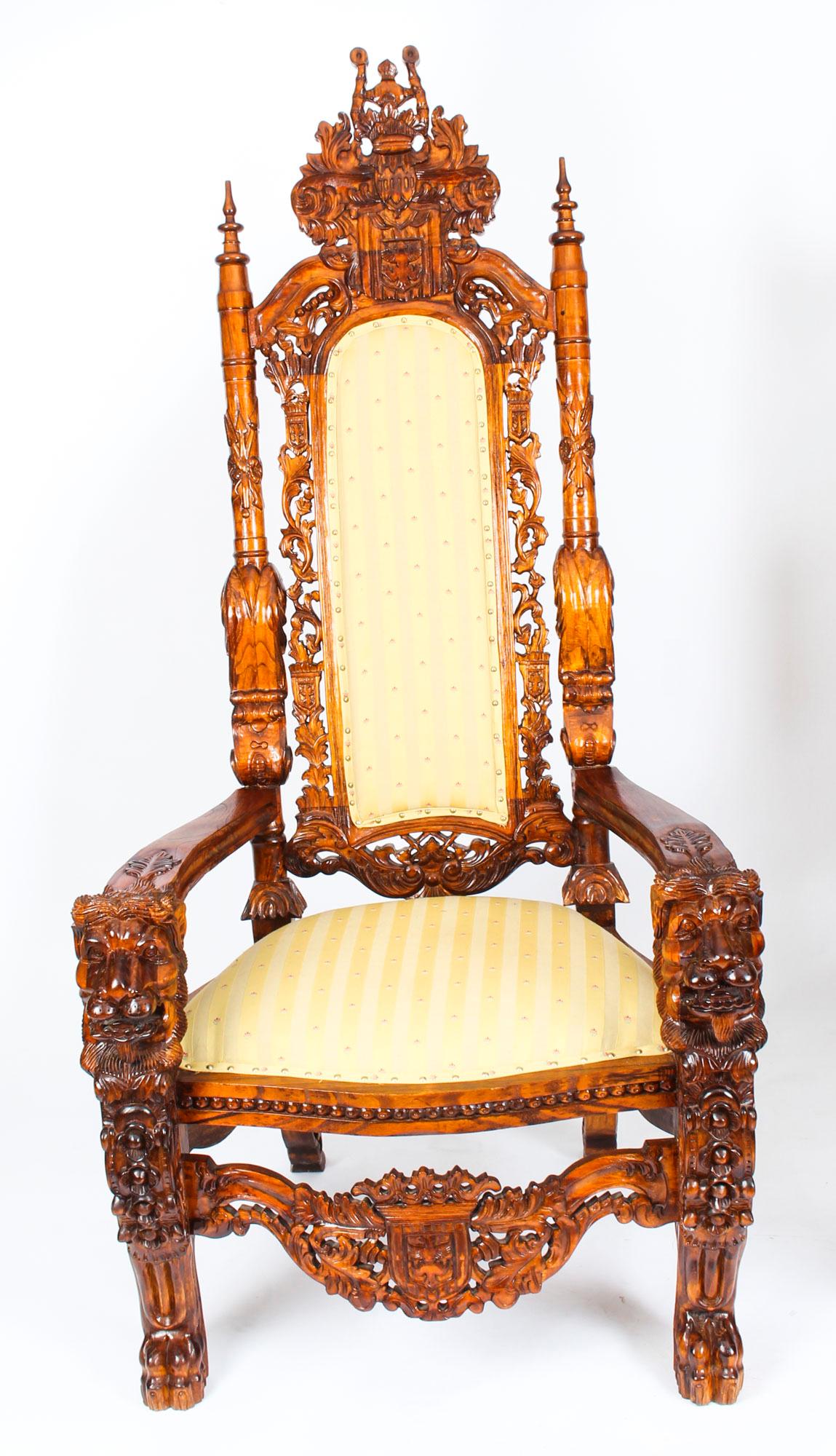 This is a monumental pair of antique high backed walnut throne chairs, circa 1900 in date.

The solid walnut frames have been beautifully hand carved with heraldry coats of arms and floral decoration. The armrests feature large carved lions heads