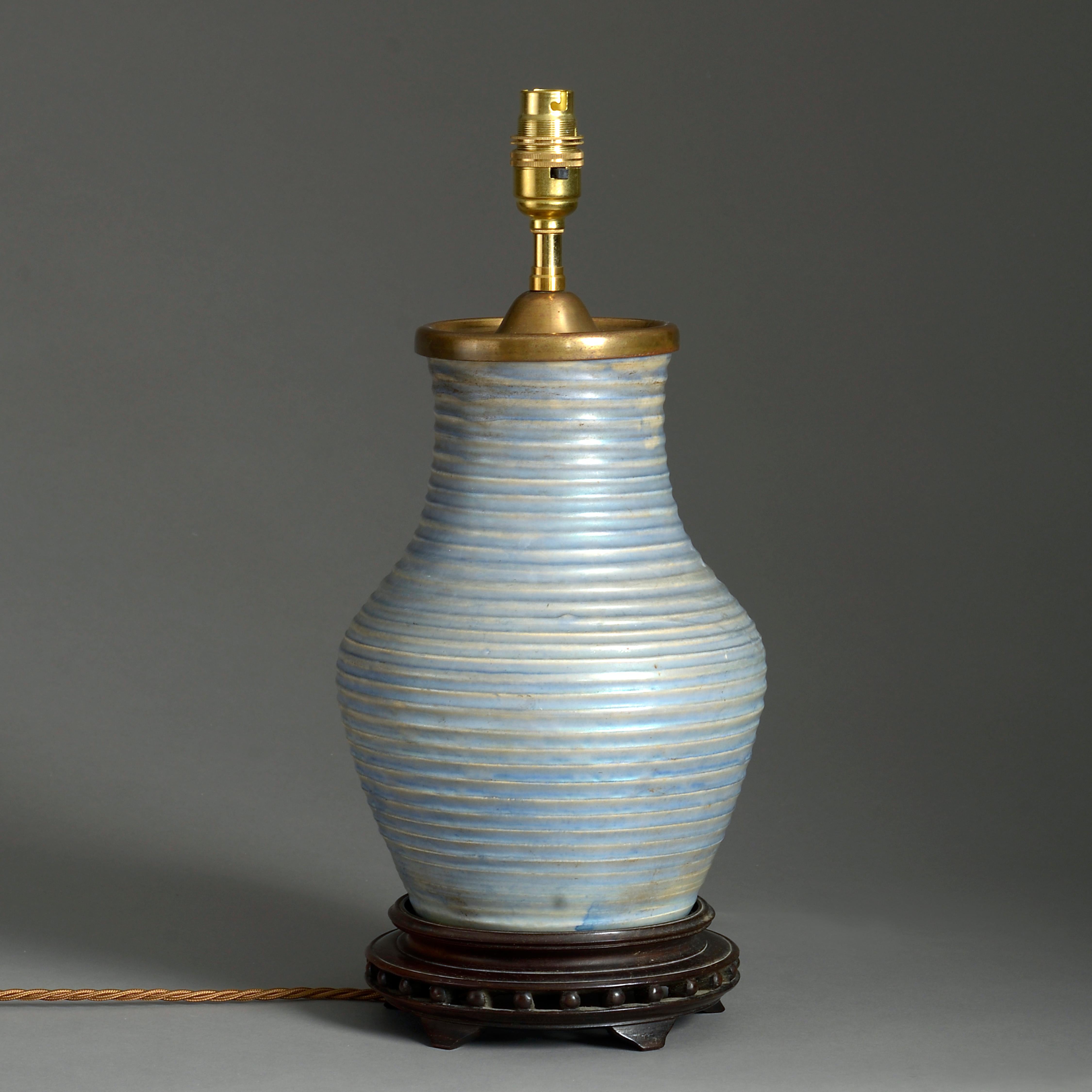 An early 20th century pale blue glazed Moorcroft Pottery vase, mounted upon an ebonised base and wired as a table lamp.



 