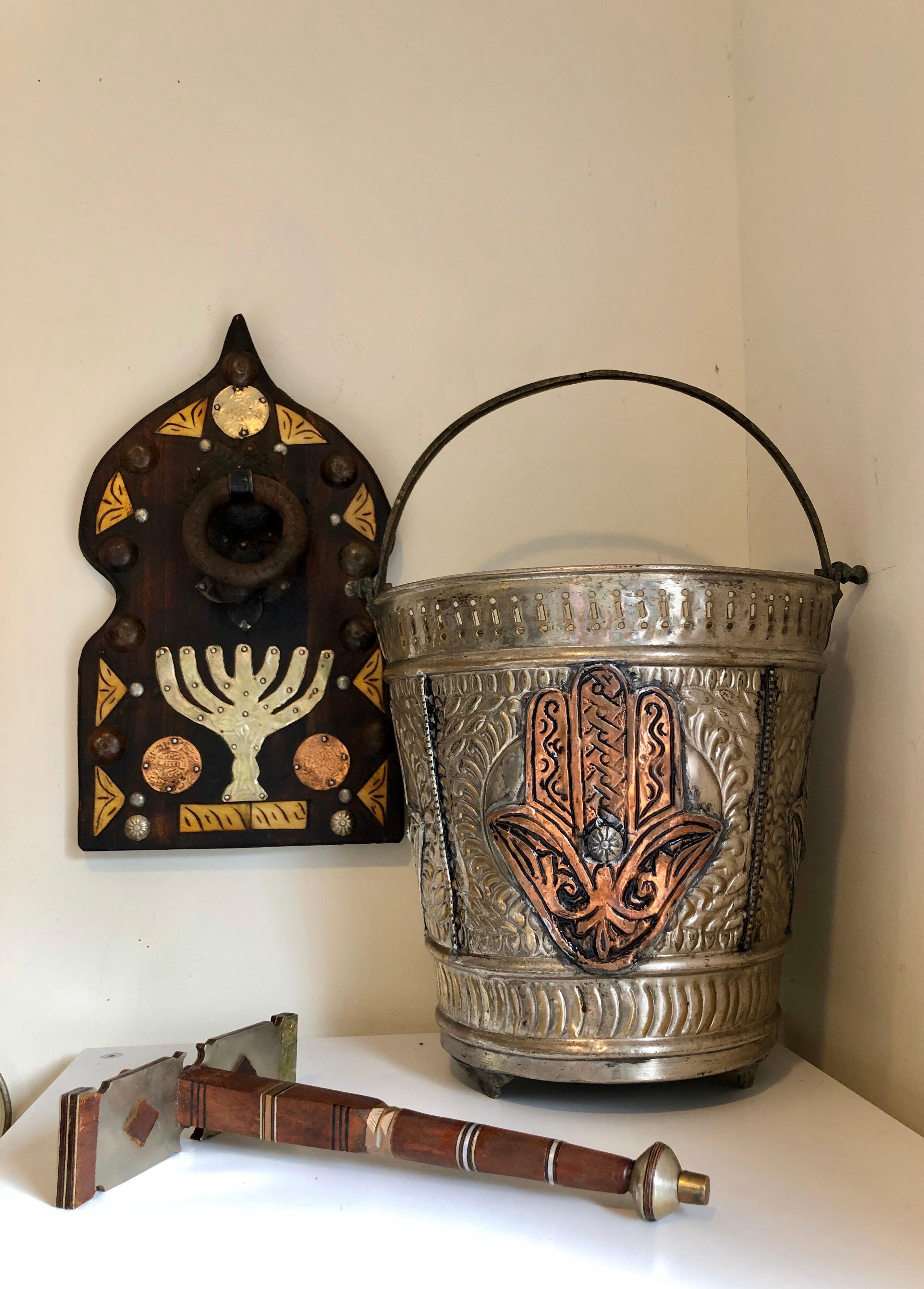 Preserved in excellent condition, this Jewish Door Knocker is made of beautiful, richly colored hand carved Tamarisk wood. Directly underneath the knocker is a cut brass menorah, with two coins on each side dated Islamic year 1331 (1912). There is