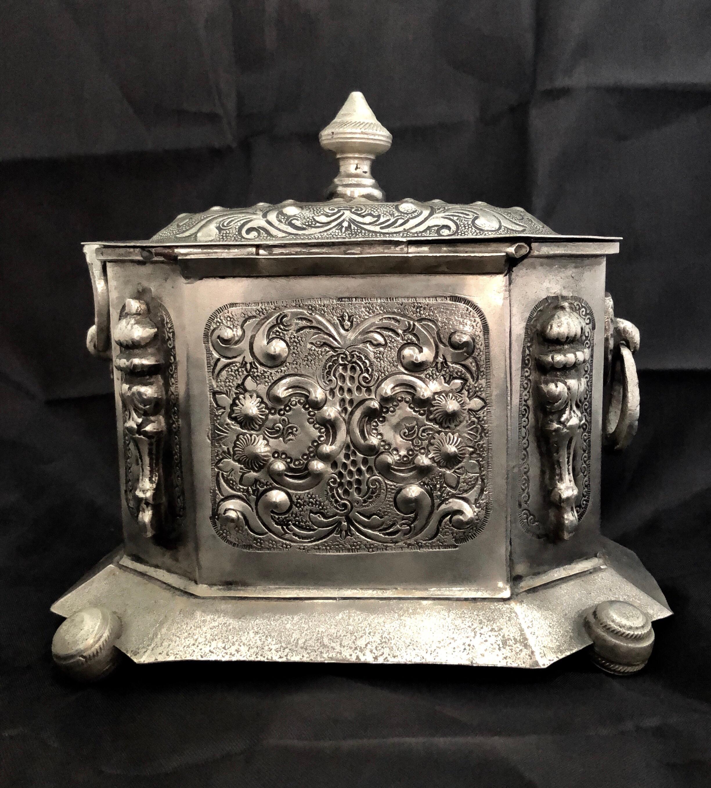 This lovely antique Moroccan silver tea box comes from the ancient city of Fes, Morocco. Used for many generations to store tea, this octagonal container is lusciously decorated in numerous different metalwork techniques. In addition to repoussée