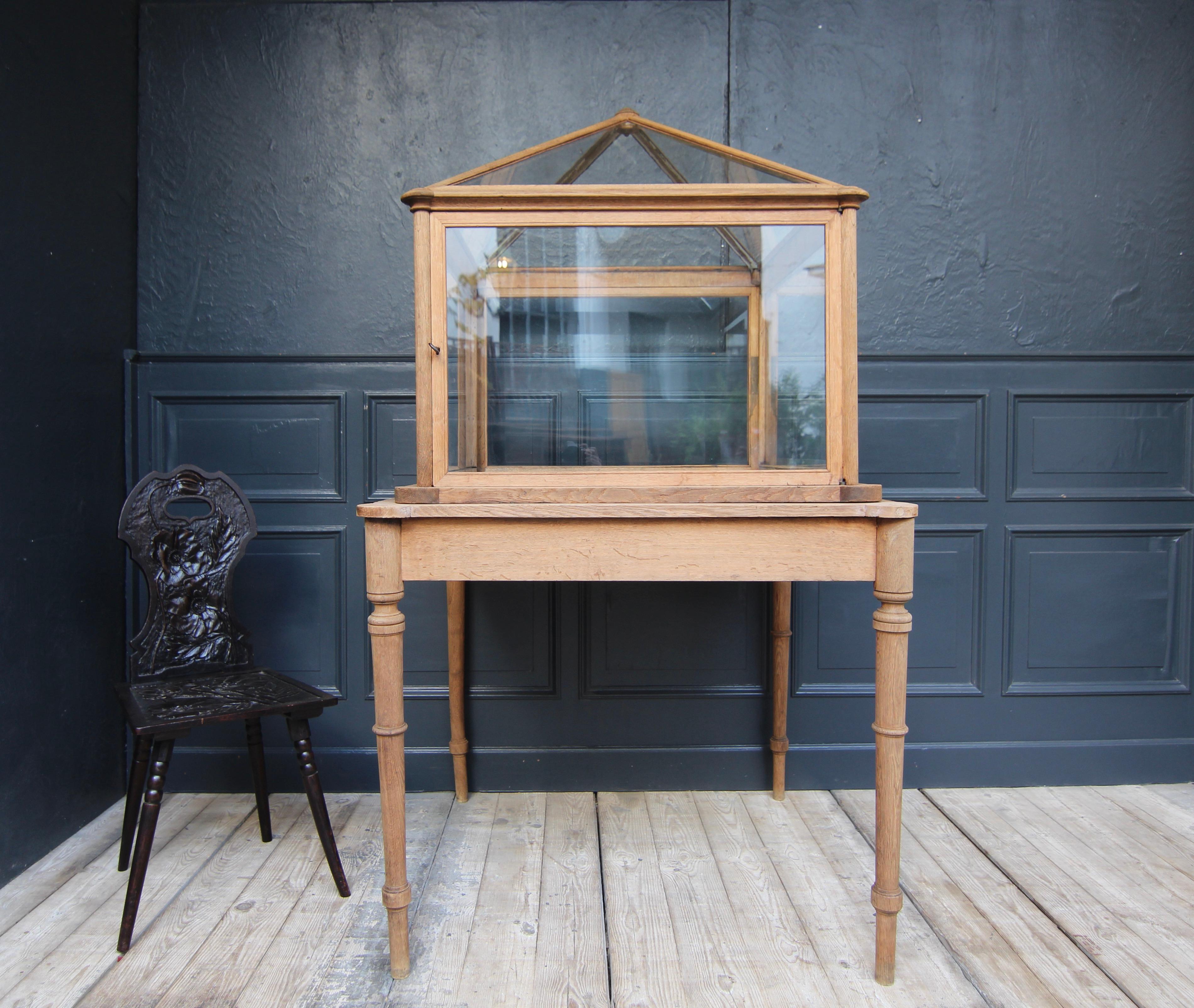 Unique museum display case from around 1900. Solidly made of oak and glazed. 

The display case with square ground plan rests on a table frame with 4 thin turned legs. The all-round glazed cuboid display case top consists of an oak frame with