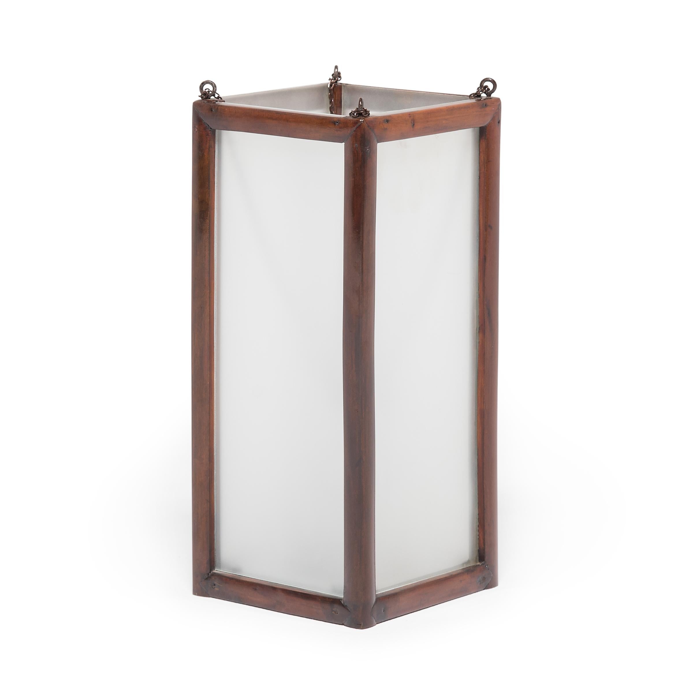 Framed in blackwood, this 19th-century lantern casts a soft glow through frosted glass. Exemplifying the simplicity found in Chinese furniture of the same era, this lantern illuminates modern interiors with a refined form that has become more