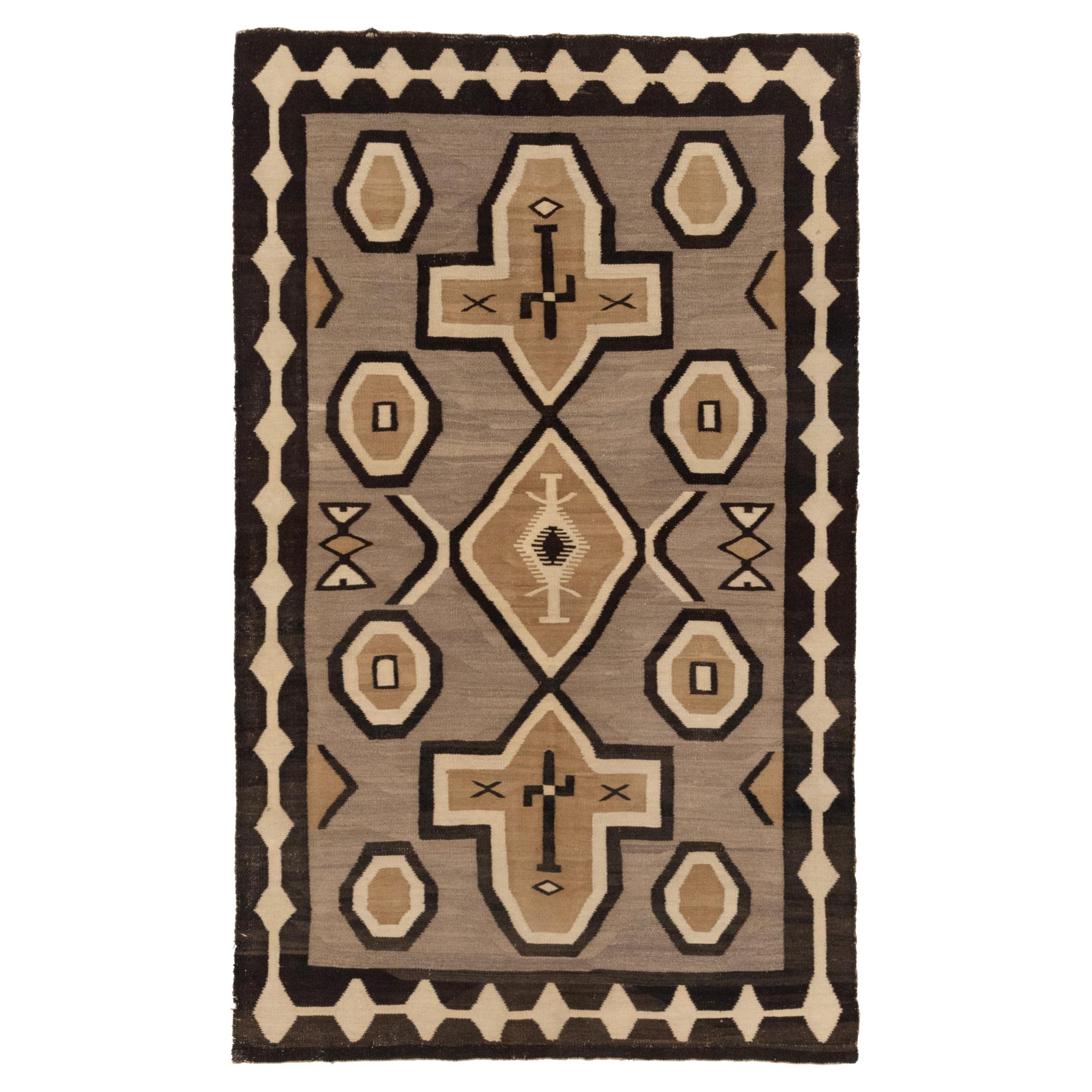 Il s'agit d'un magnifique tapis Navajo du début du siècle, aux couleurs terreuses, en parfait état.