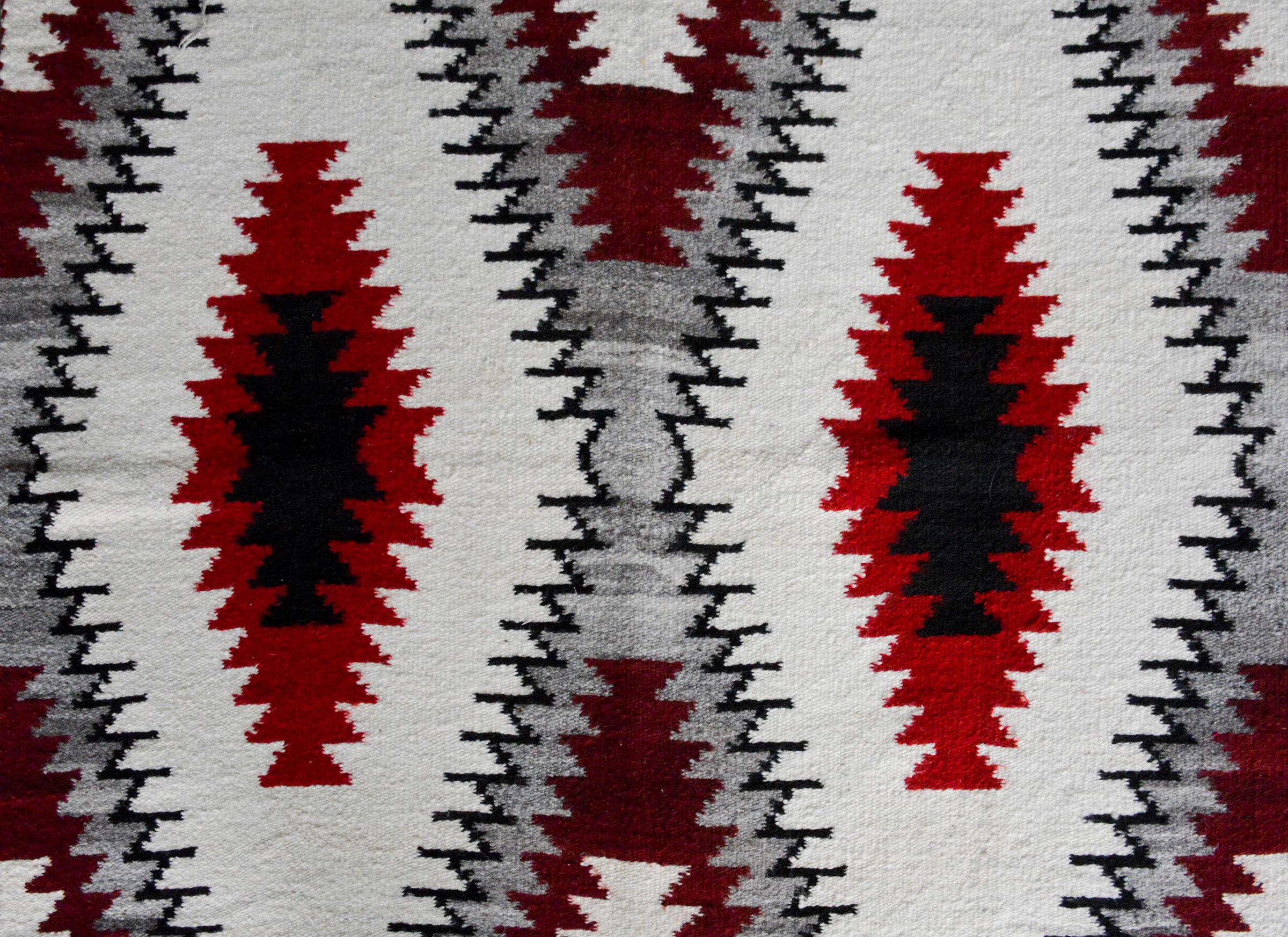 Eine auffällige Navajo-Decke aus dem frühen 20. Jahrhundert mit einem auffälligen Rautenmuster aus purpurroter, weißer, grauer und schwarzer Wolle.