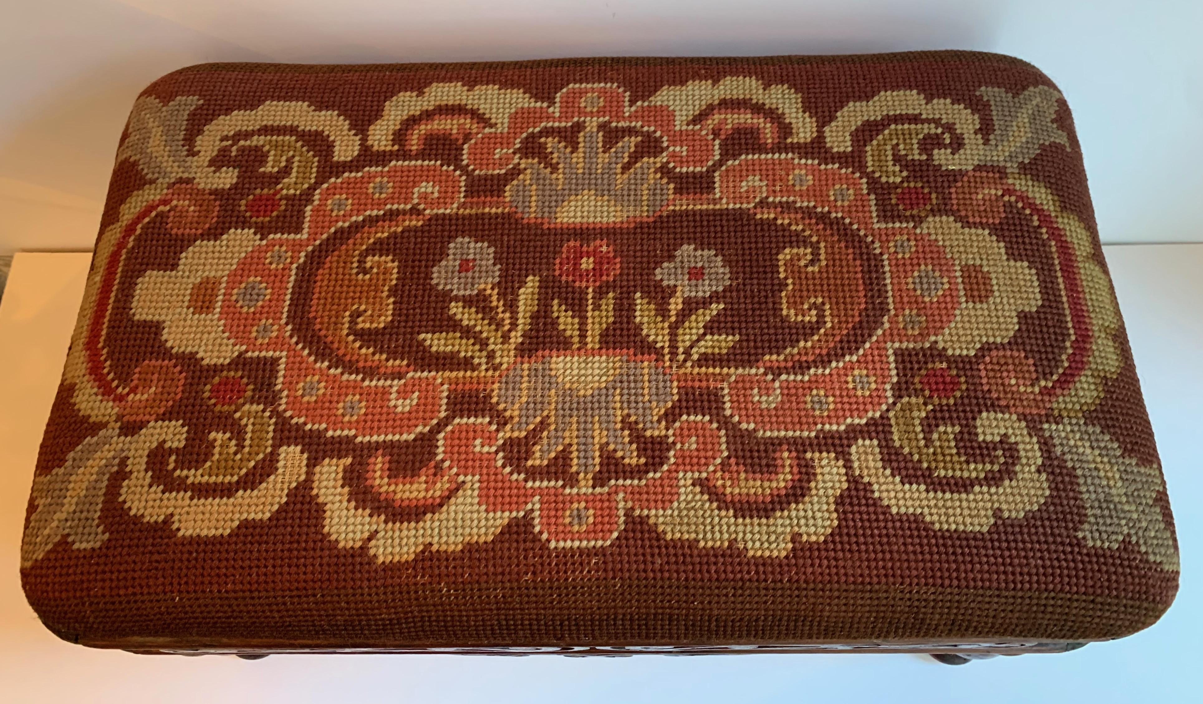 A handsome hand carved stool with hand finished needle point / embroidery upholstery.