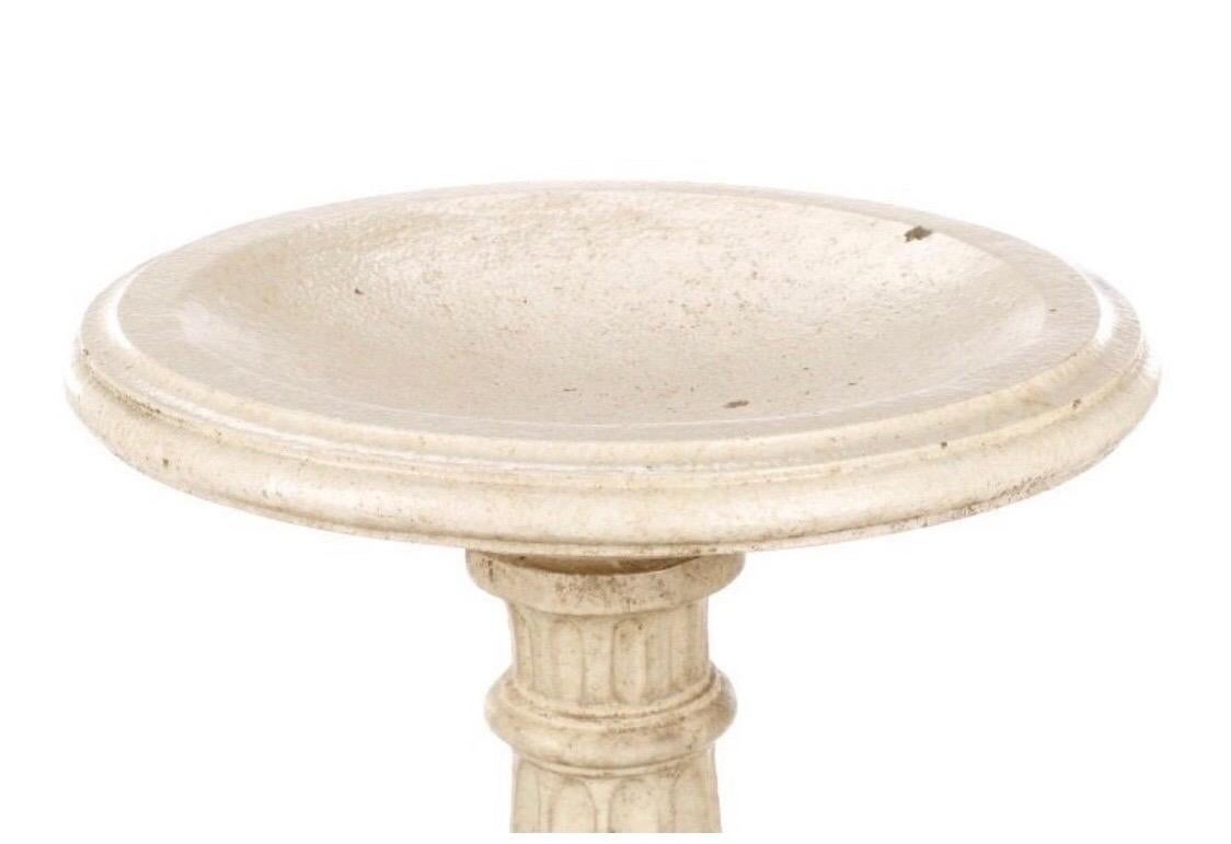 Early 20th century neoclassical glazed terracotta and plaster bird bath with all-over faux marble cream toned glaze, with cast terracotta round shallow well surmounting a plaster fluted column shaft flaring at bottom terminating in a rolled foot and