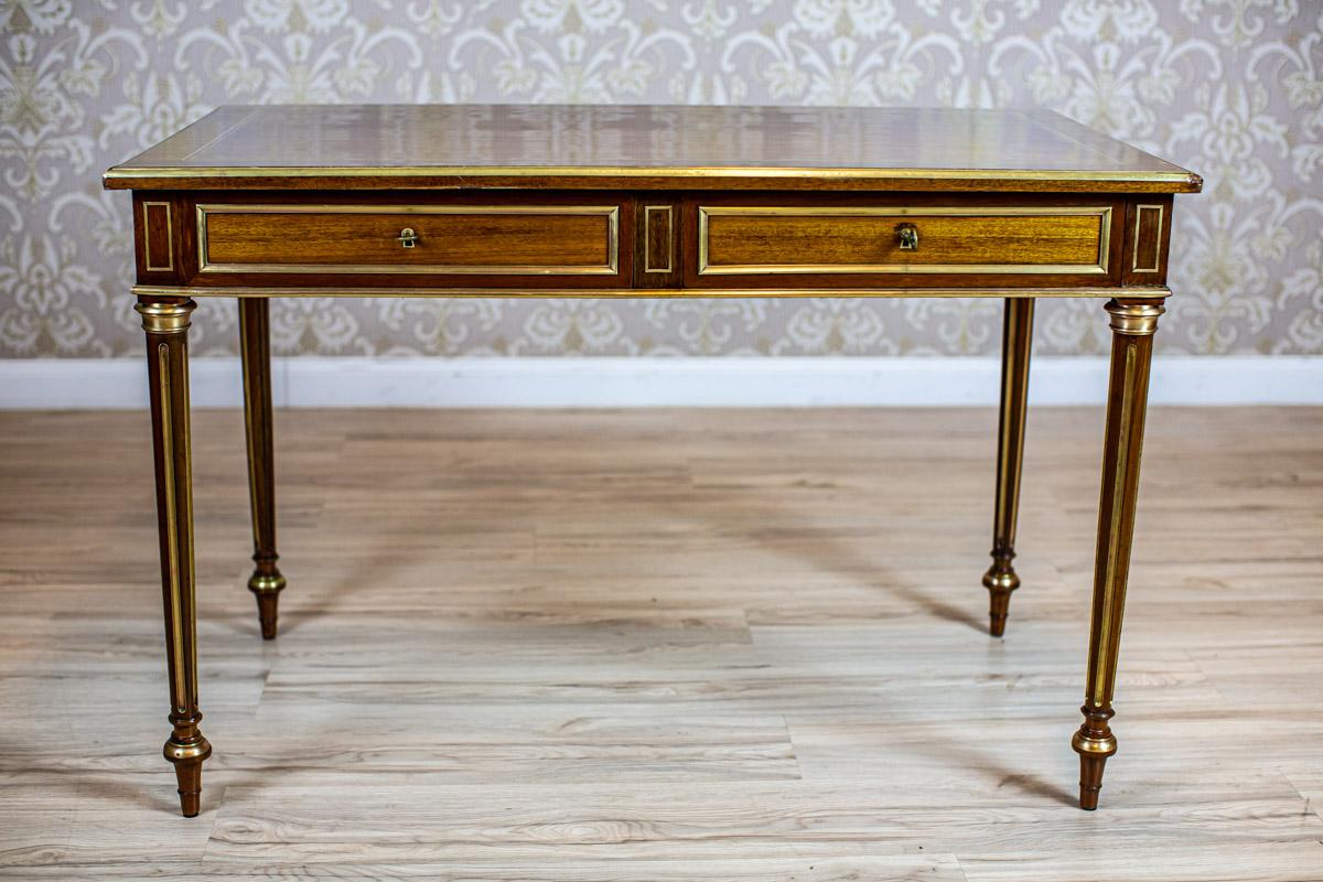 Early 20th-Century Neoclassical Writing Desk Inlaid with Brass

We present you a Neoclassical writing desk from the early 20th century.
It is placed on high fluted legs supporting a rectangular top with two drawers.
The whole piece is inlaid with
