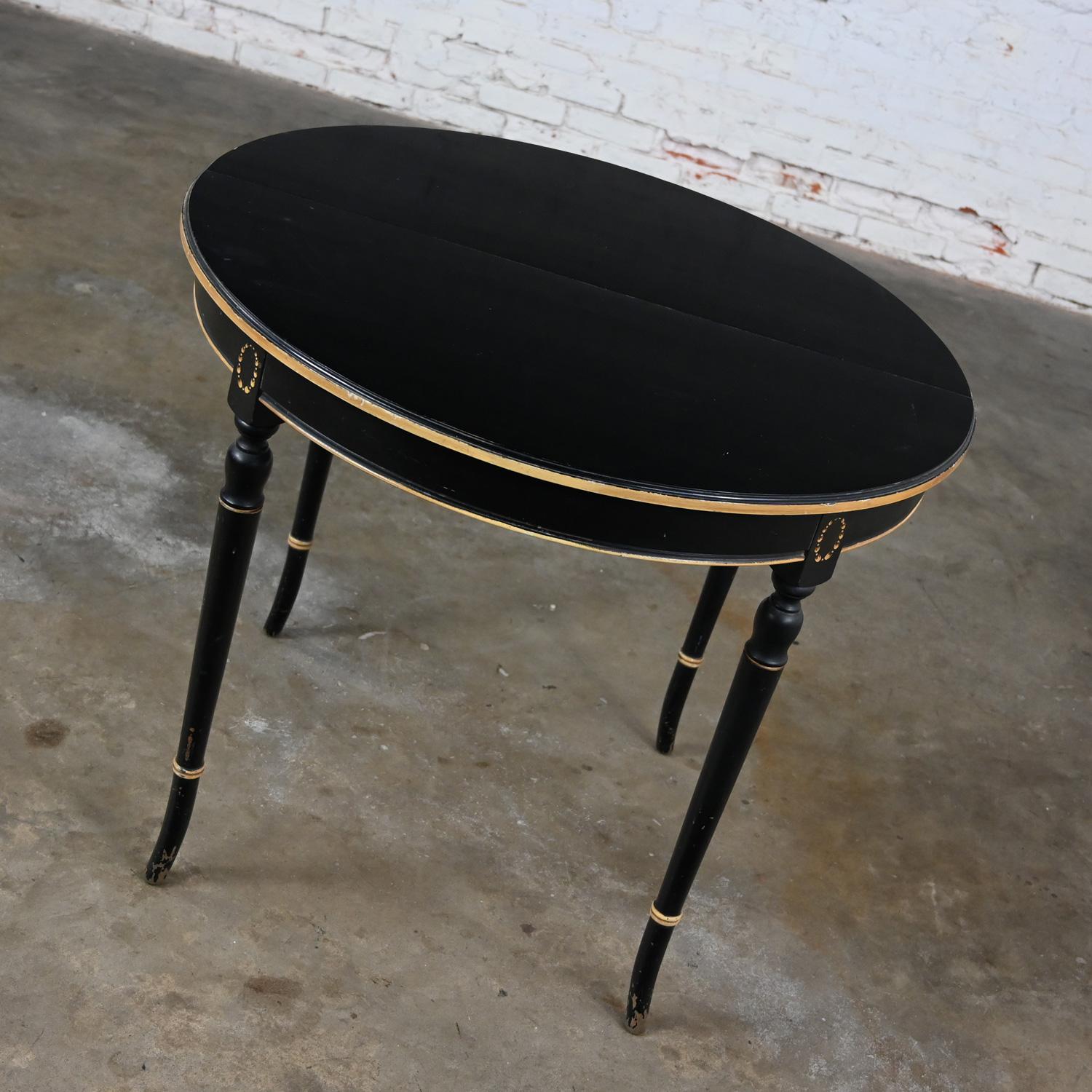 Handsome vintage Neoclassical round dining table or center table black painted with an all-over age distressed finish and gold details. Beautiful, distressed condition, keeping in mind that this is vintage and not new so will have signs of use and