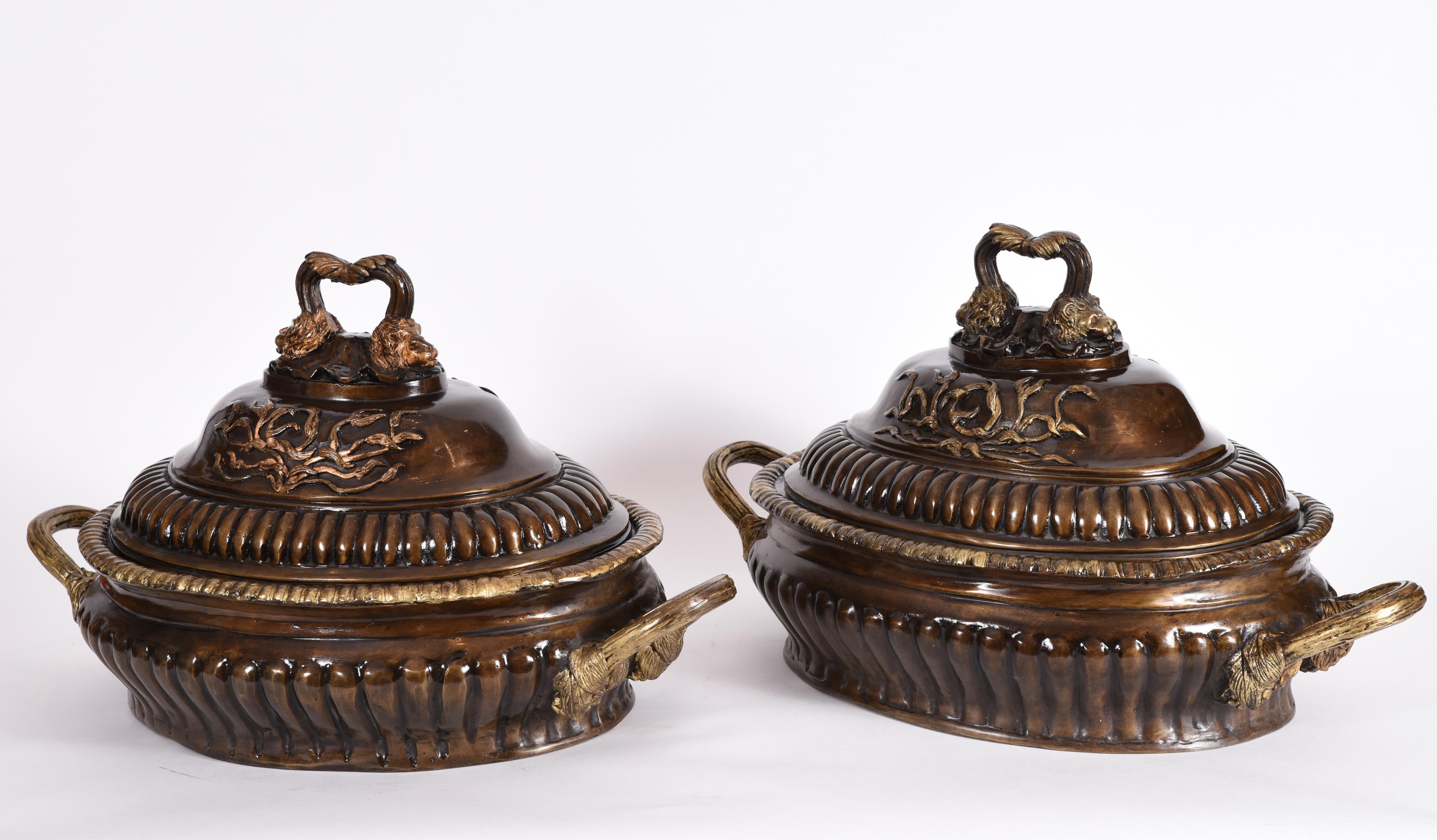 Early 20th century pair of neoclassical style patinated bronze covered tureen form tableware centerpieces. Each piece is in excellent vintage condition. These are bronze they are heavy. Each one measure about 24 inches length x 13.5 inches width x