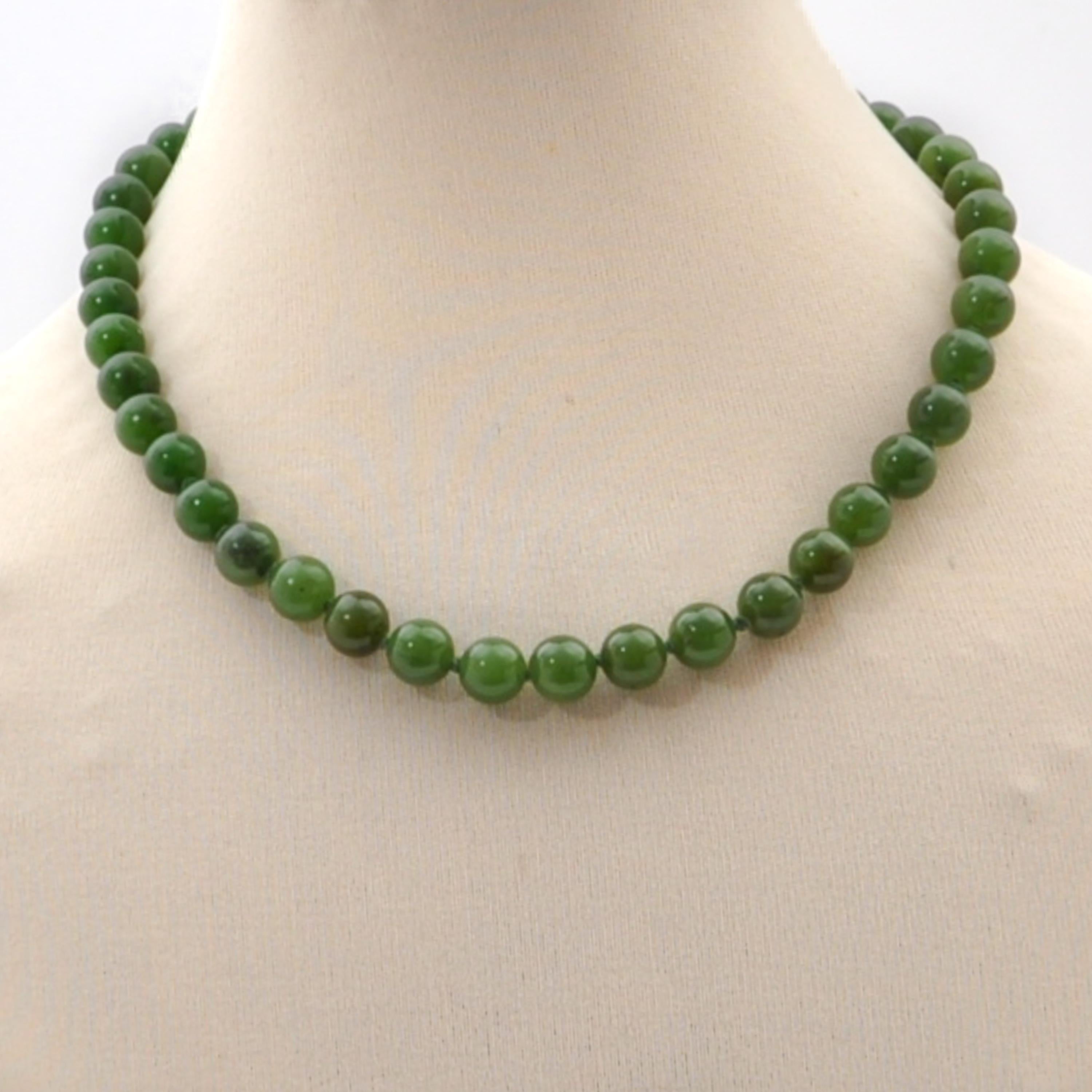 A vintage green nephrite jade beaded necklace made of one single-strand. The necklace consists of round-shaped nephrite jade stones. The jade beads have a nice green color and are equally sized. To keep some space between the beads, the thread is