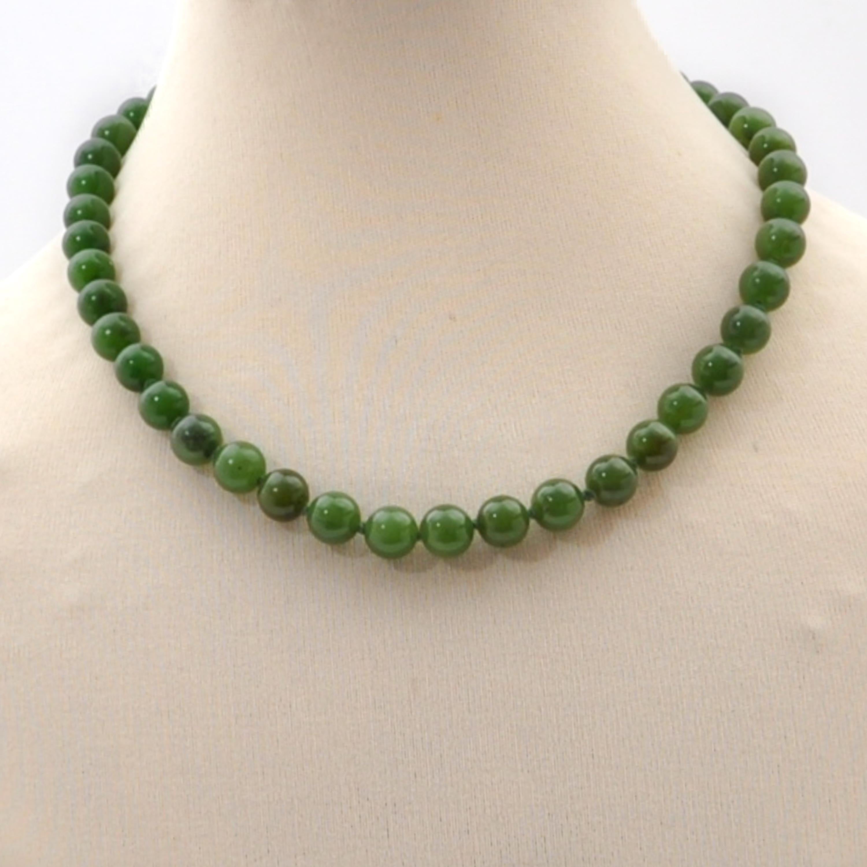Una collana vintage di perline di nefrite verde composta da un unico filo. La collana è composta da pietre di giada nefrite di forma rotonda. Le perle di giada hanno un bel colore verde e sono di dimensioni uguali. Per mantenere un po' di spazio tra