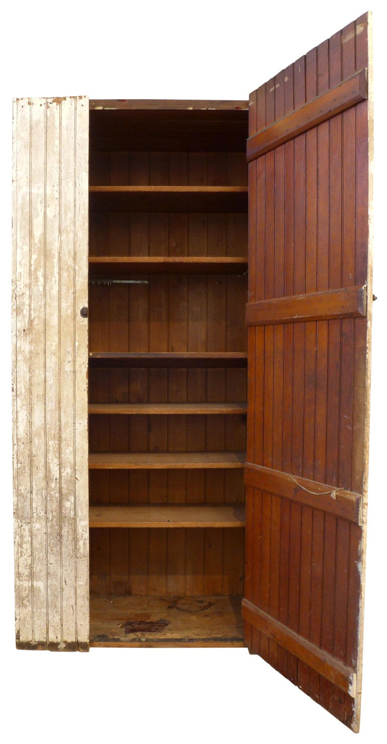 A fantastic, monumental, turn-of-the-century primitive wood cupboard. Wearing its original, now wonderfully-mottled, whitewash, a large, rectilinear storage edifice with a vertical wood slat exterior. Incredible, impressive scale with desired wear