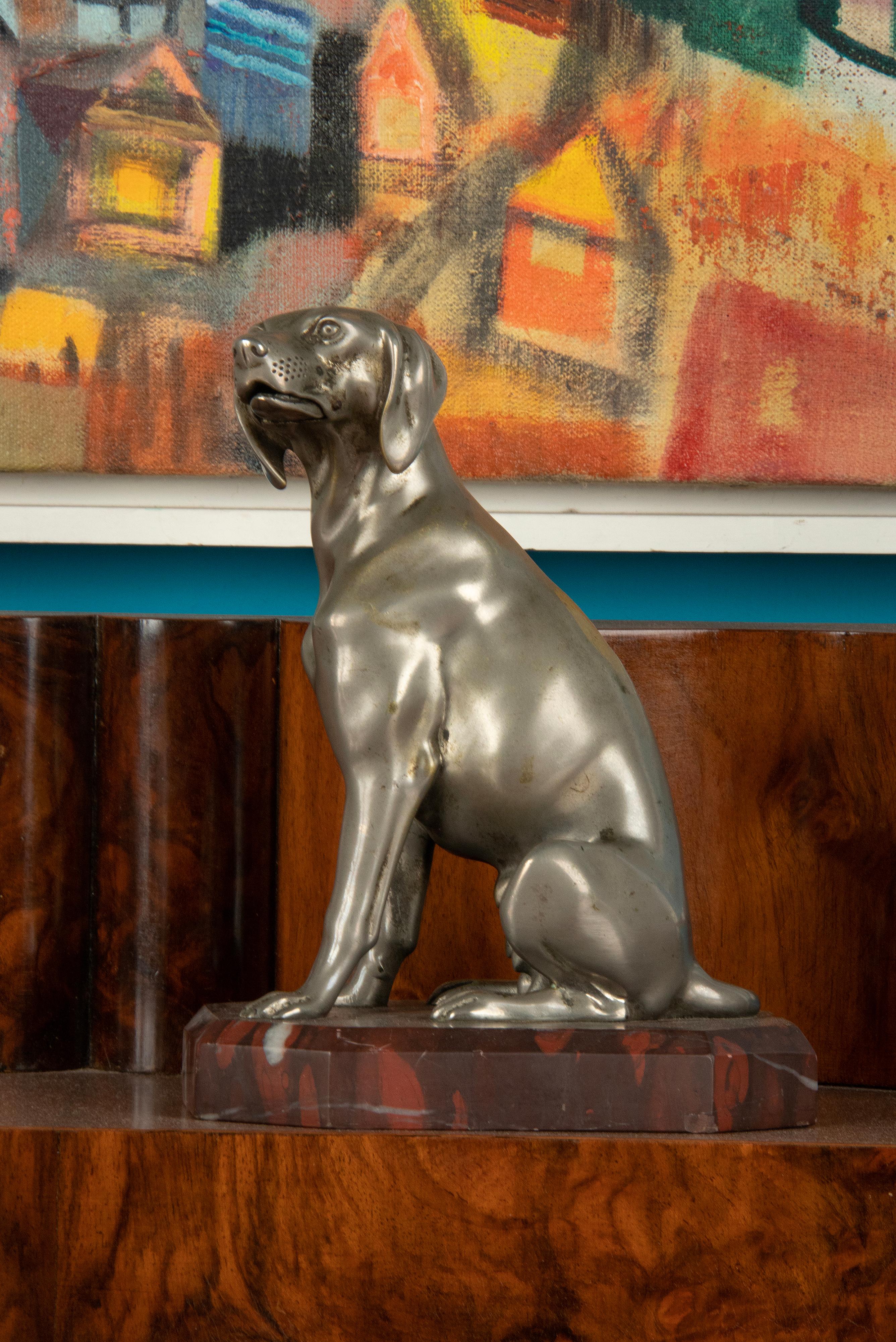An antique sculpture of a dog made of nickel-plated spleter (zinc alloy). Sitting on a red “Griotte” marble plinth. Made in France, circa 1910-1920. No signature.