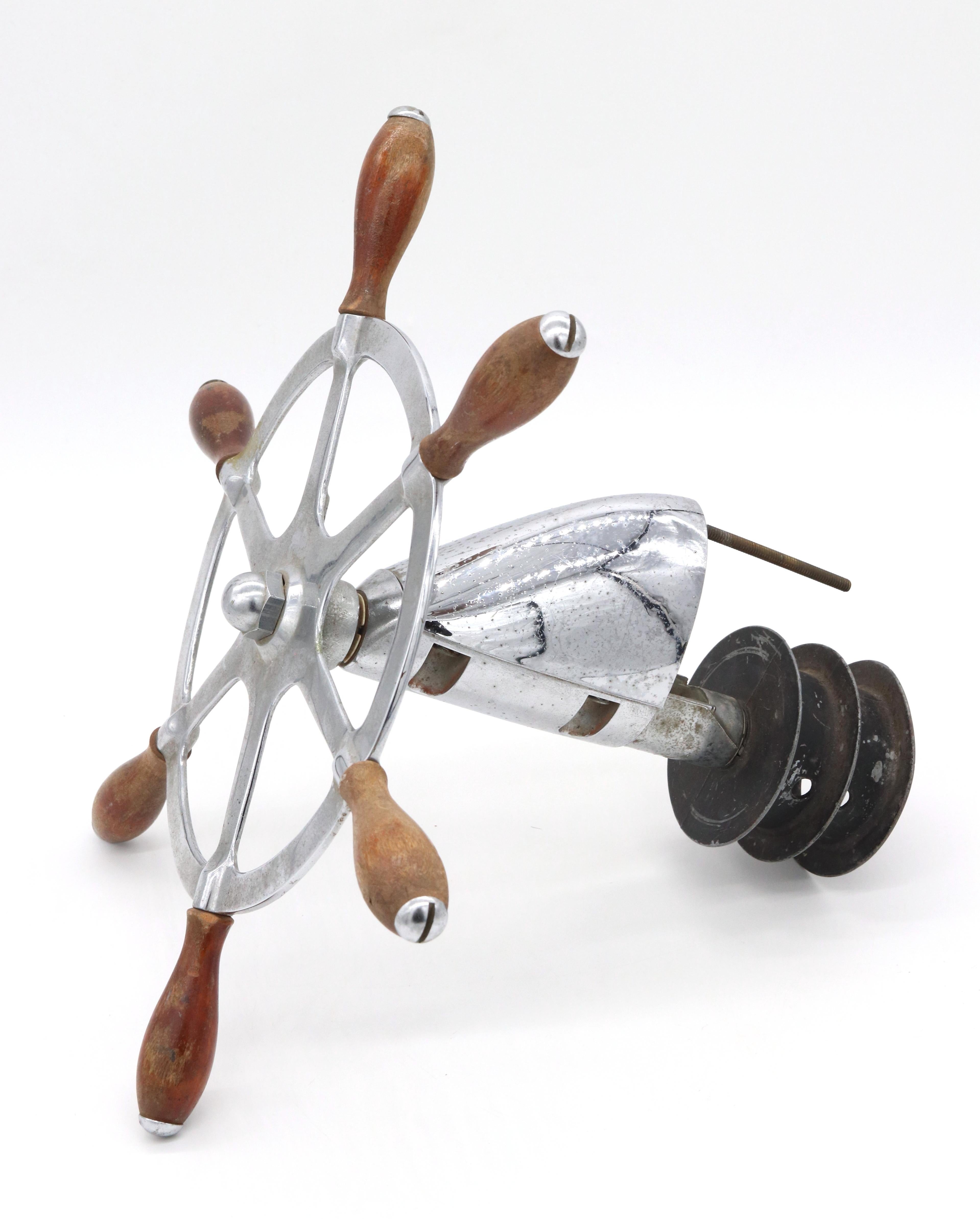 Early 20th Century nickel plated six spoke brass and iron yacht wheel with teak handles in good condition, showing only some wear to the wood from usage and age. It has a double pulley and rotating shield. Embossed 7080 ABW. Minor gold paint from