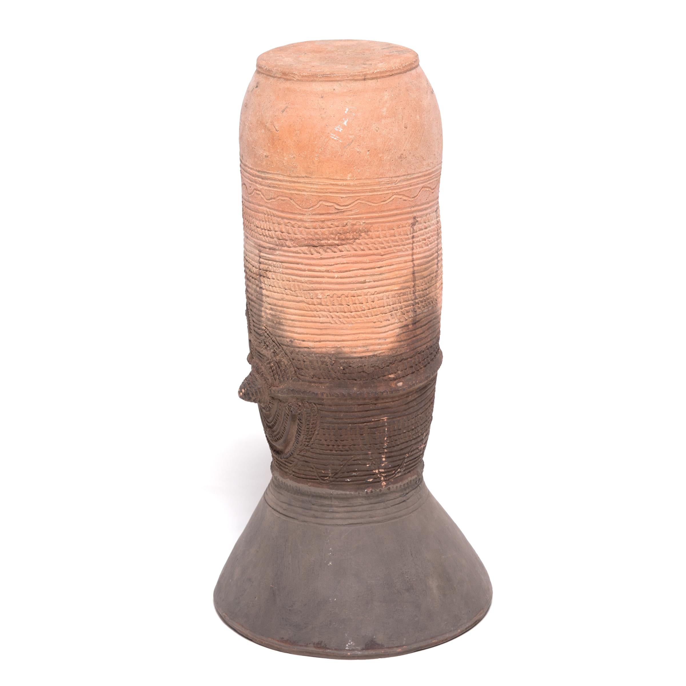 The Nupe people of Nigeria were touted as some of the finest ceramicists in Africa. Everyday objects like this elegant, cylindrical vessel support received detailed attention. This flaring terra cotta form would have been buried halfway in the