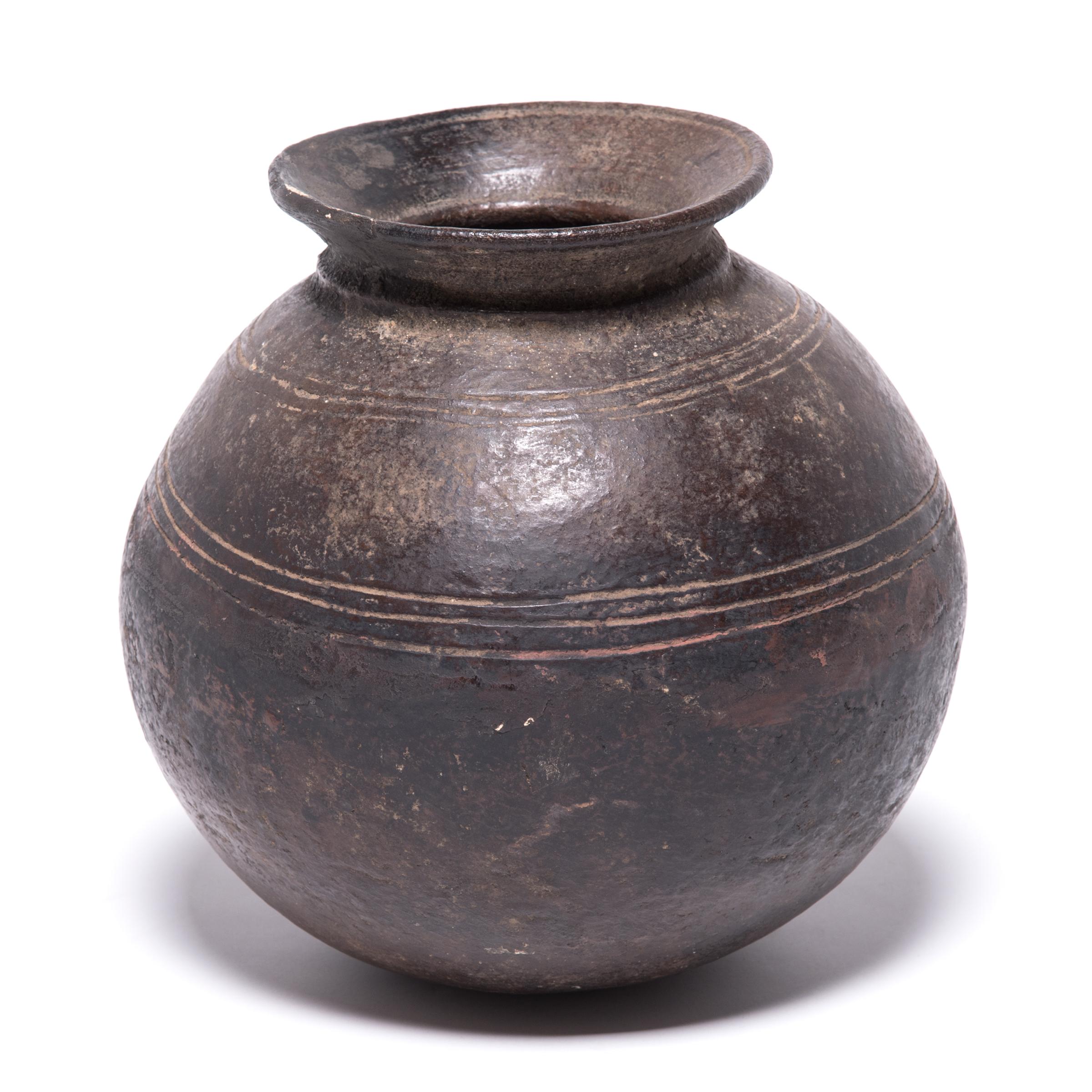 The Nupe people of Nigeria were touted as some of the finest ceramicists in Africa. Everyday objects, like this water vessel, received detailed attention. The vessel's varied textures come from its functional design. The dimples and bands were