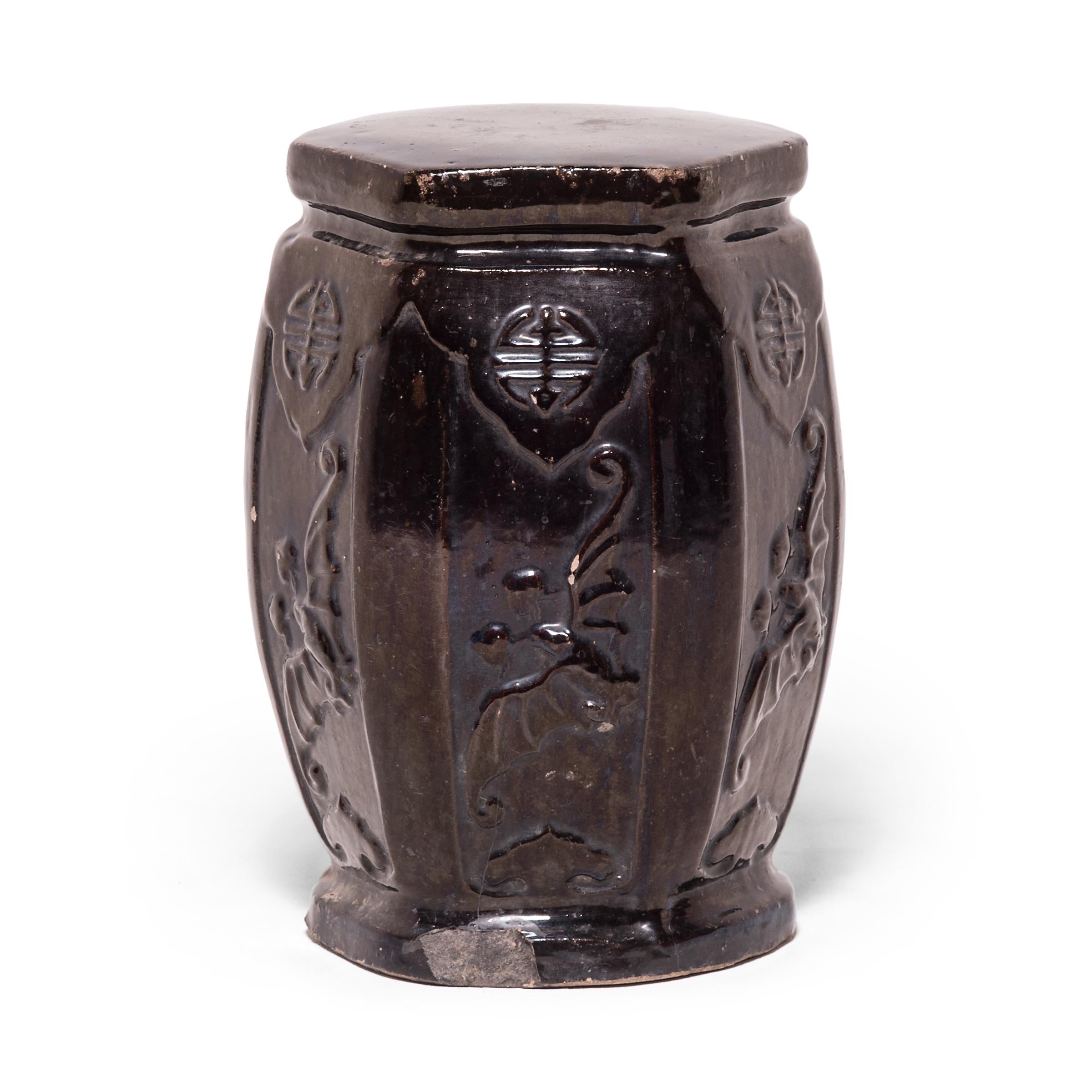 This early 20th century garden stool from China's Hebei province has the proportions of a traditional drum-form stool, but its hexagonal shape and waisted ends make it an unusual find. Although the dark glaze appears perfectly even from afar, a