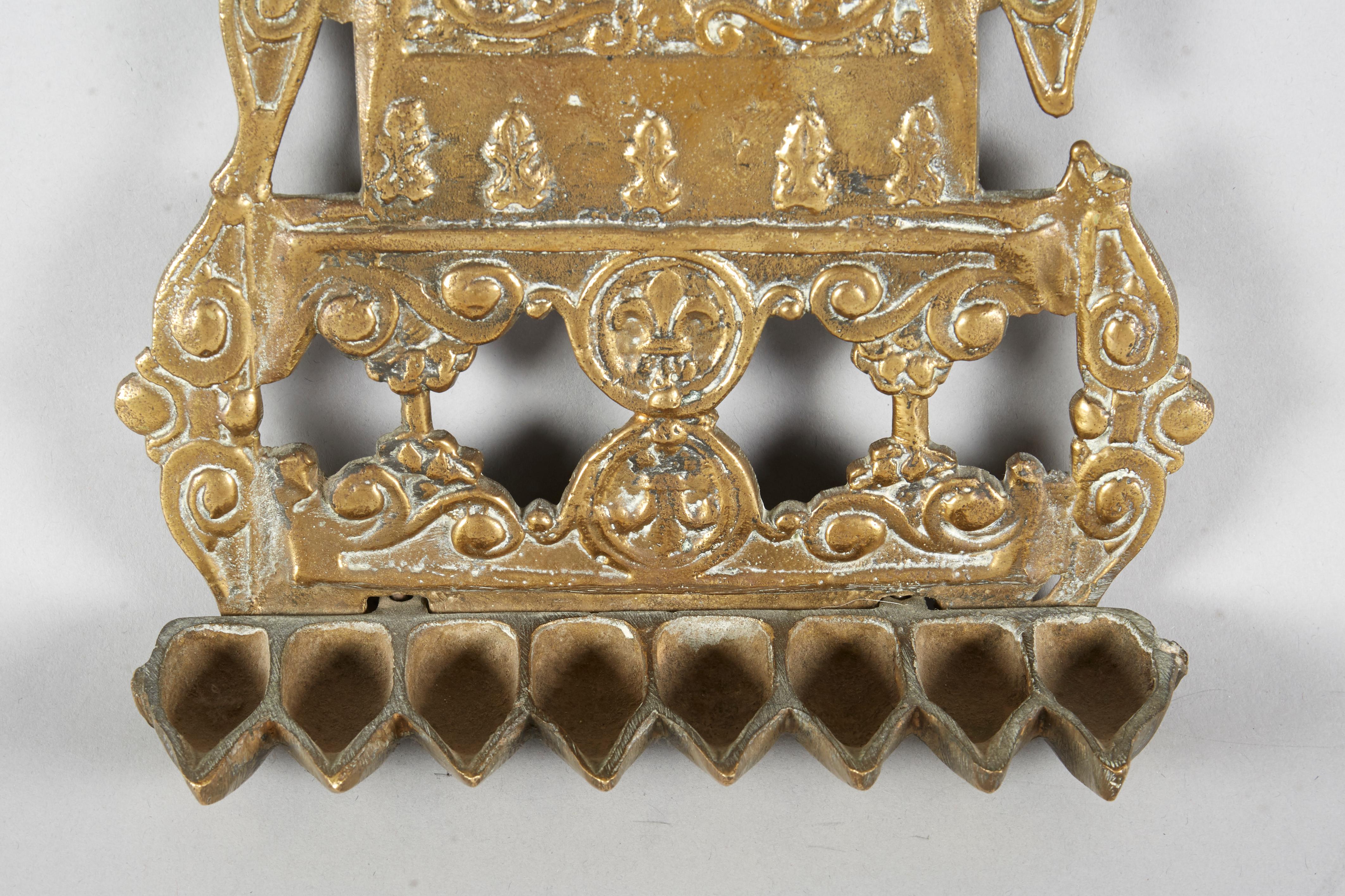 Chanukka-Lampe aus Messingguss, Algerien, Ende 19. oder Anfang 20. Jahrhundert. 
Einzigartiges Design. Die Rückseite ist mit pflanzlichen Motiven und einer Reihe von Medaillons, einem kleinen Schild und einem Rechteck mit Fleur-de-Lis-Dekor