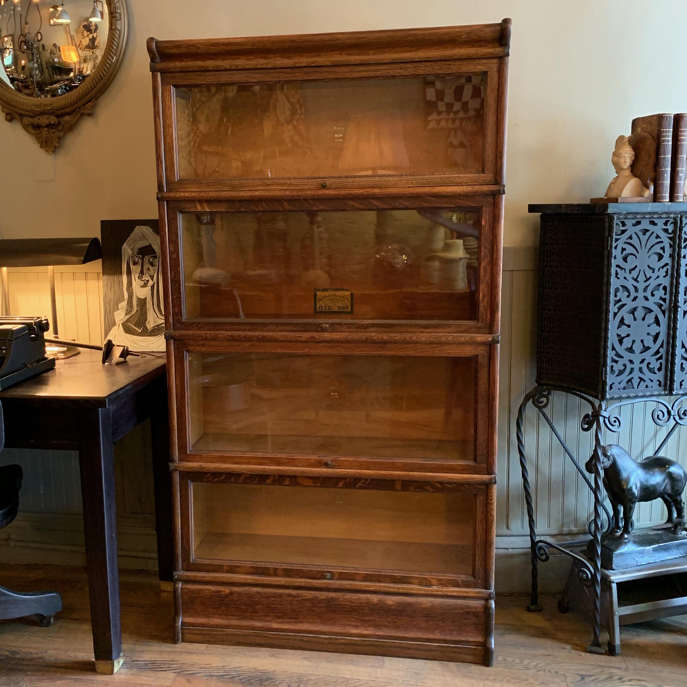 Early 20th century, four-stack, sectional bookcase, barrister case by The Globe Wernicke Co. features interlocking stacks of oak with glass fronts and steel scissor hinges, circa 1920s.

Macey stickers are from manufacturer The Macey Co. which