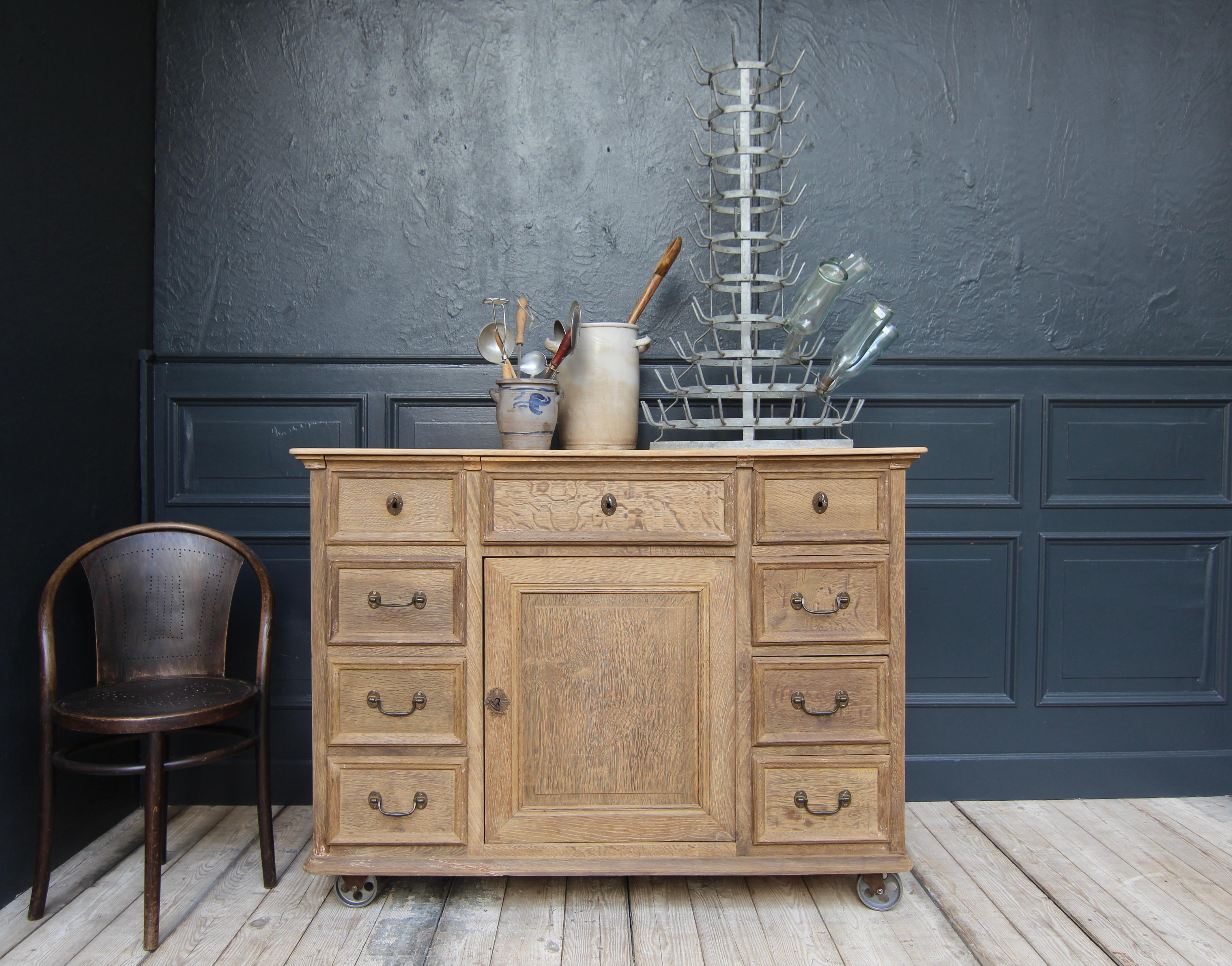 Vintage shop furniture from the early 20th century. Made of solid oak wood. Ideal as a kitchen island or service station.

Frame construction oak carcass standing on 4 newly mounted industrial metal castors with softwood top slightly overhanging on