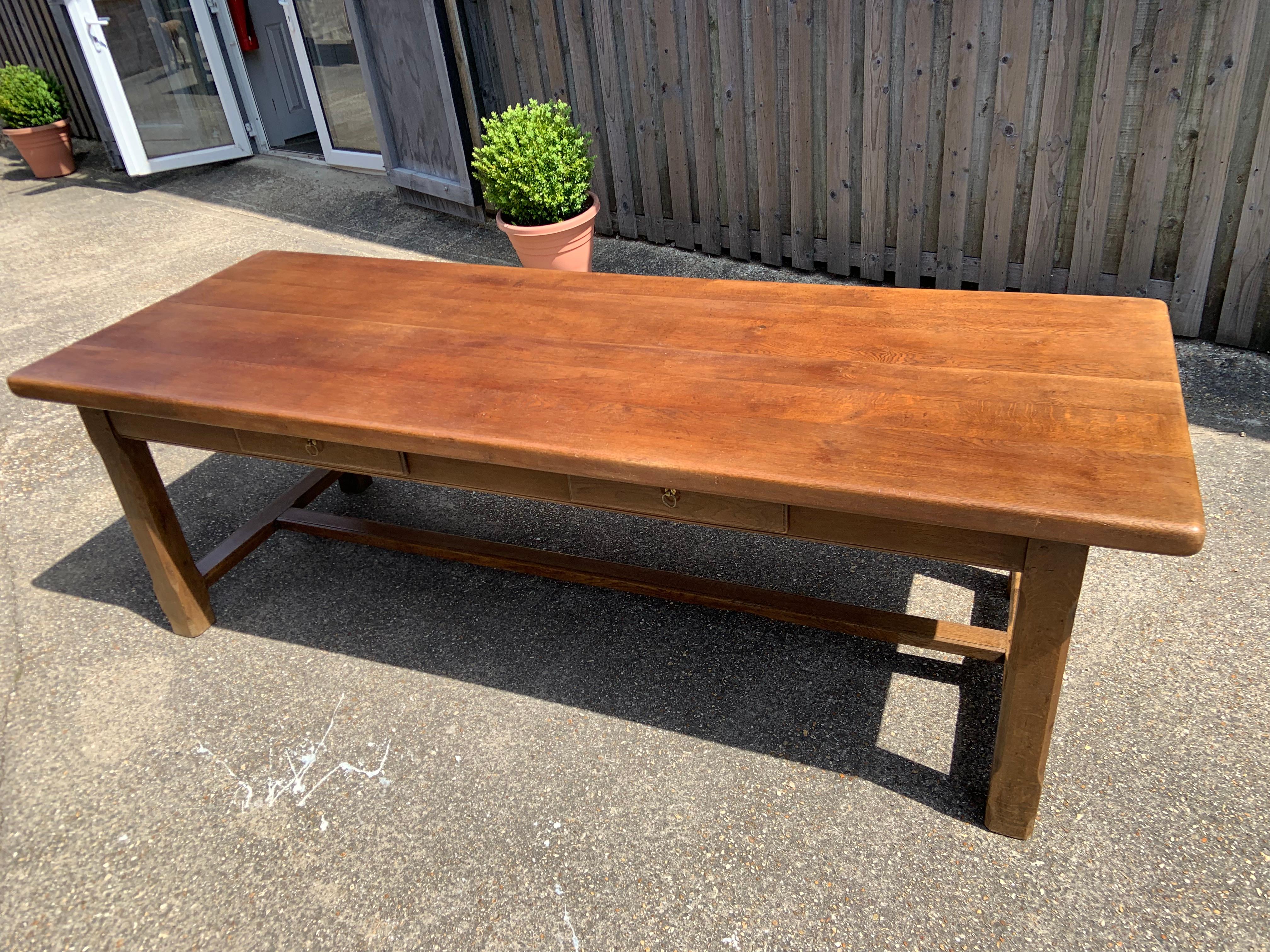 Table de ferme en chêne du début du XXe siècle avec deux tiroirs latéraux. Très grande table de ferme avec un large plateau, une bonne couleur et une base originale très robuste. Les pieds sont très épais et robustes, ce qui en fait une table idéale