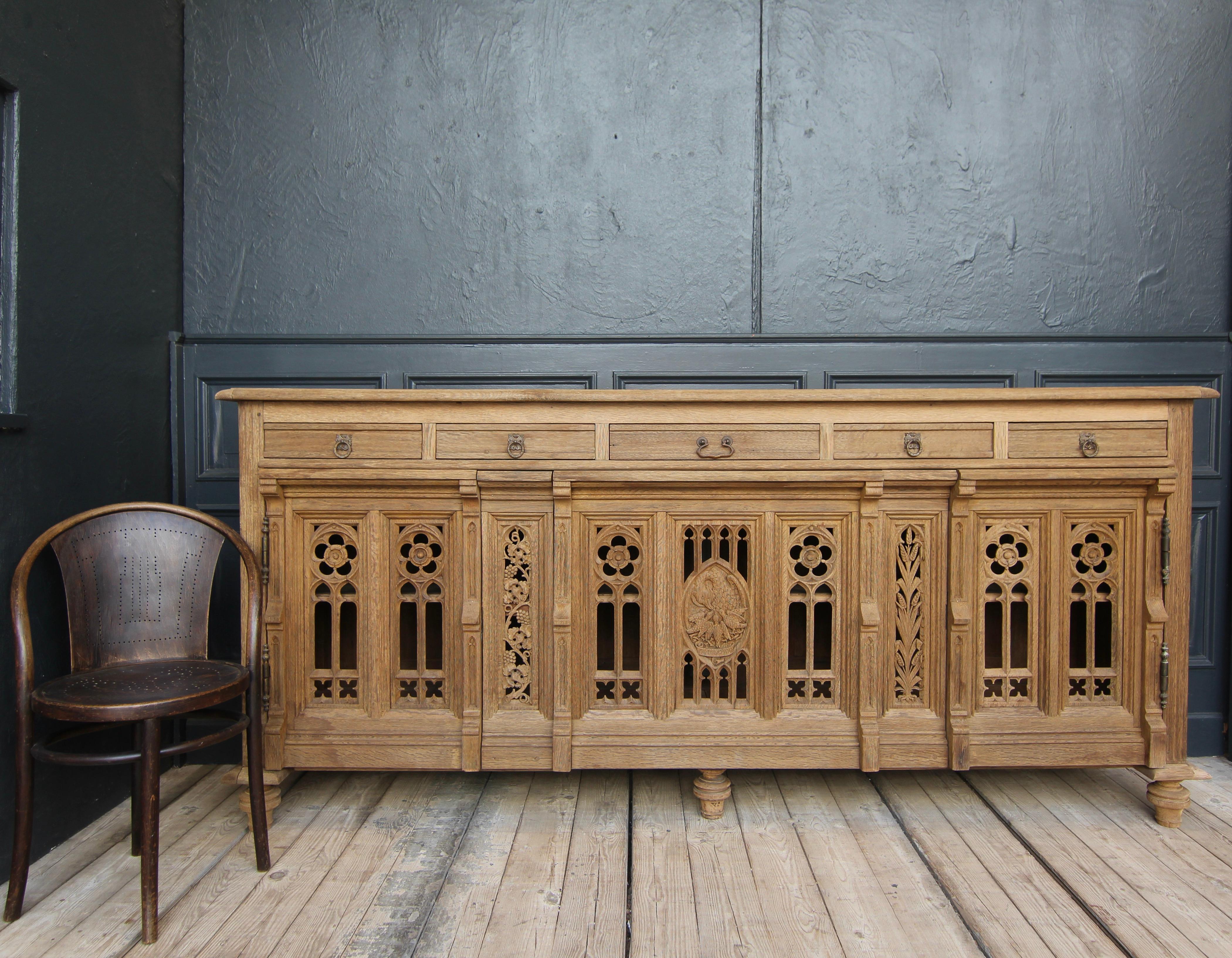 A late 19th century or early 20th century one of a kind gothic revival sideboard from a church made of solid oak.

Stripped and sanded of the old wax, revealing the beautiful surface and texture of the natural oak wood.

Half-height corpus with
