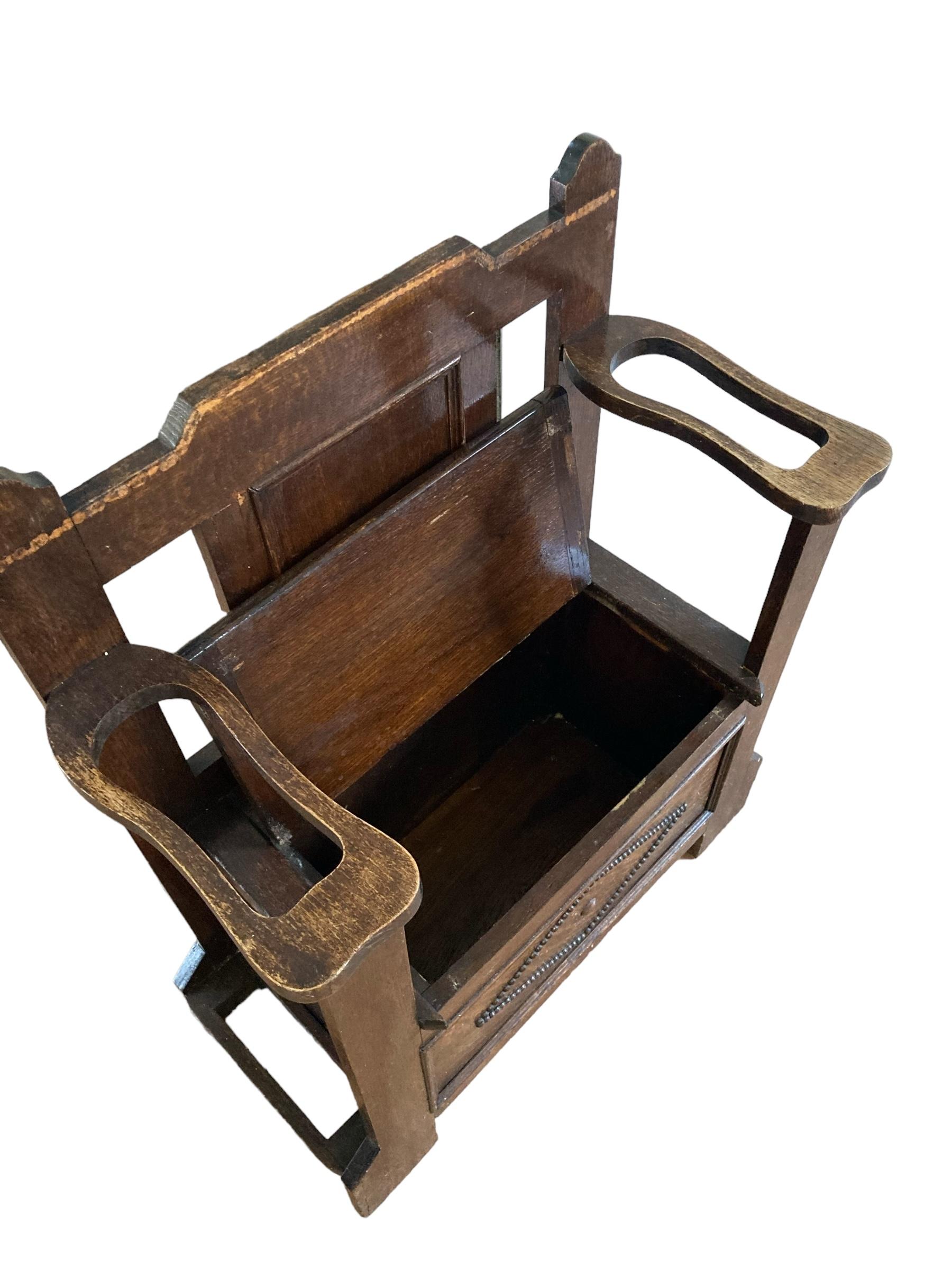 Early 20th Century Oak hall seat having a panelled back with a lift up seat for storage and stick stands to either side.The arms of the stand are to support umbrellas/sticks which fit neatly into the tin drip trays at the base of the stand. Panelled