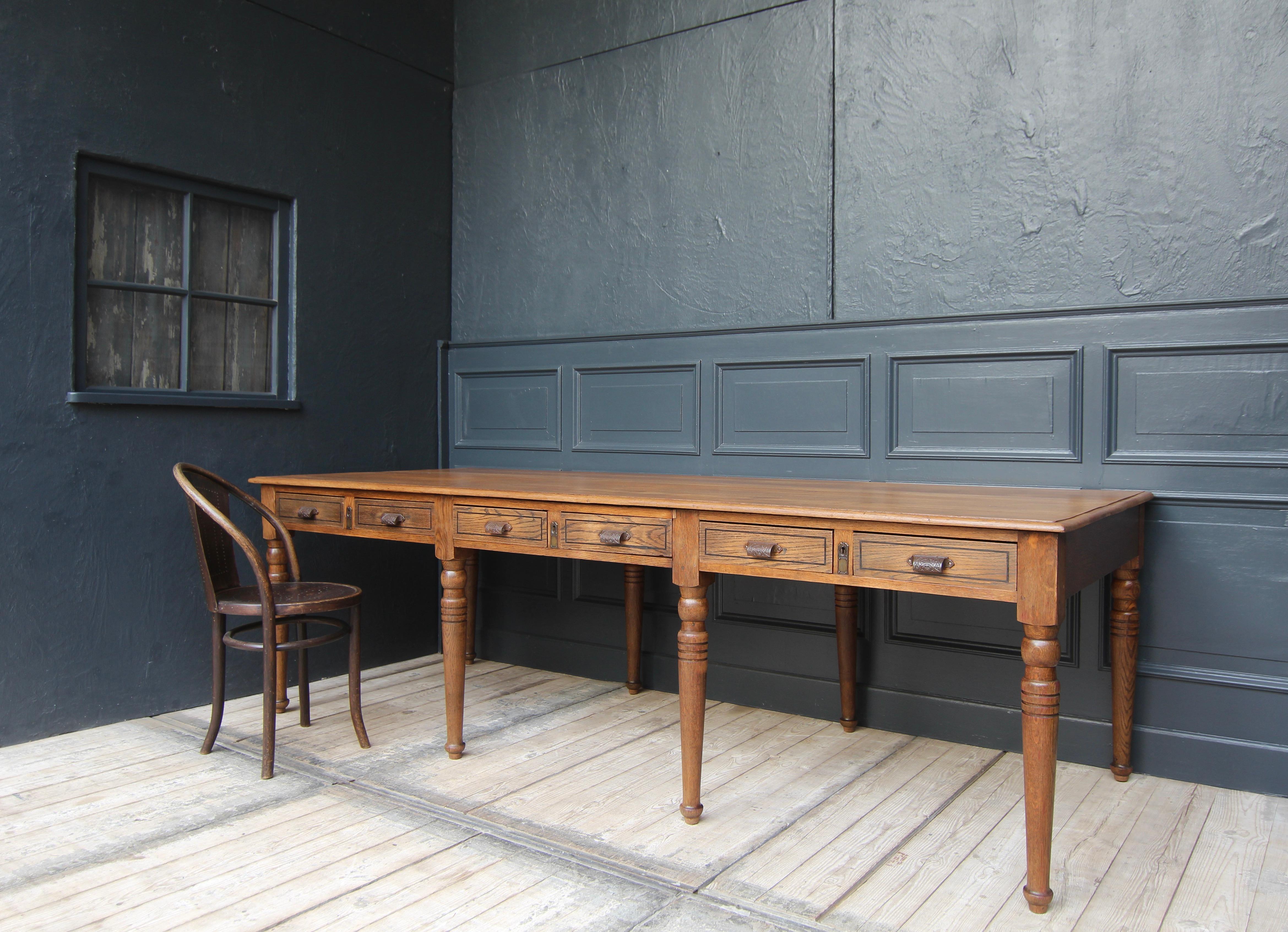 A large French library table from the early 20th century. Solidly made in oak. Also ideal as a dining table for 6-8 persons.

Table frame standing on a rectangular ground plan with 8 turned legs, frame and profiled top protruding slightly all