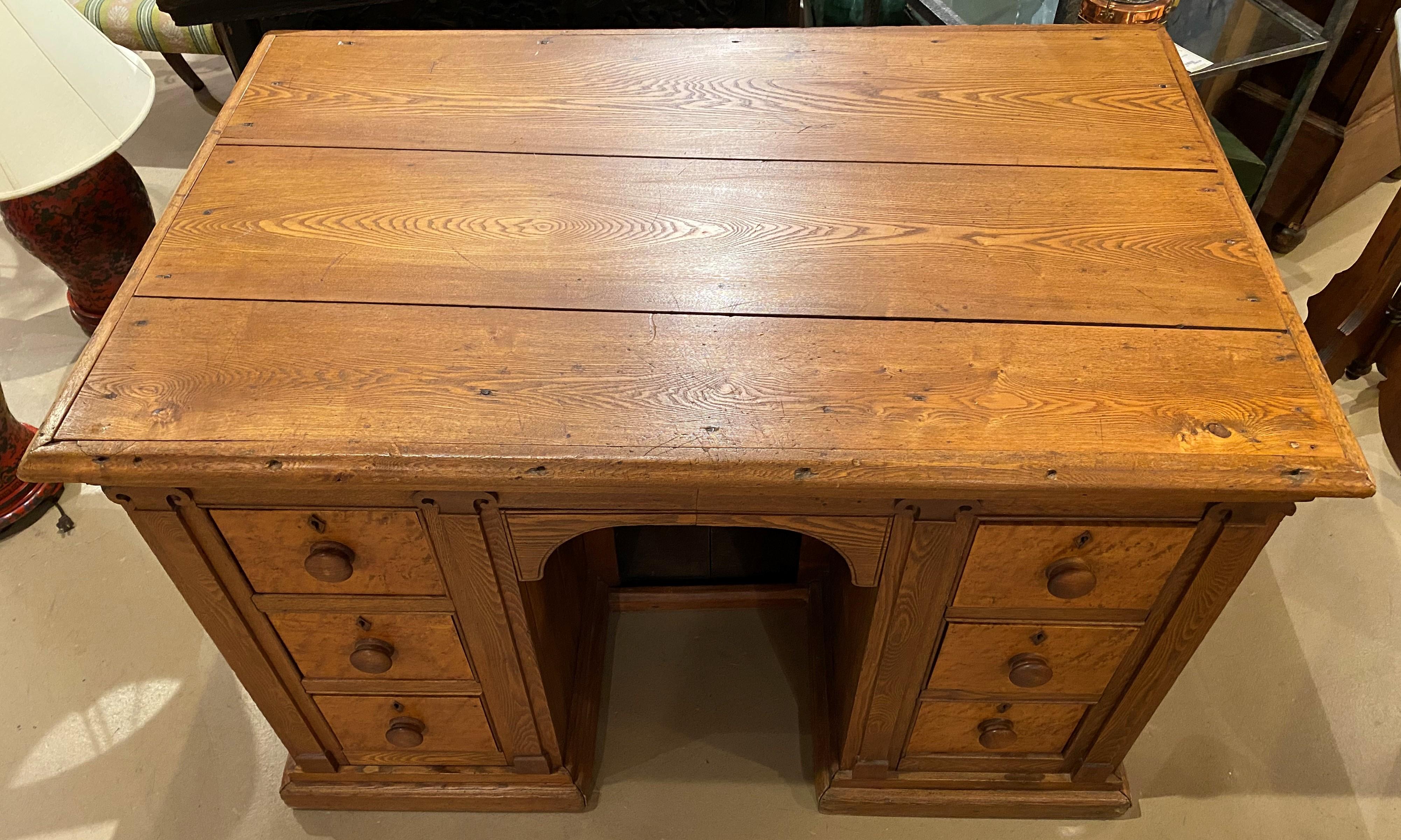 A nice example of an oak store paneled counter or six drawer kneehole desk, each dovetailed drawer with round wooden pulls and birdseye maple drawer fronts, a molded edge rectangular top, and a hidden single shelf storage area in the back of the