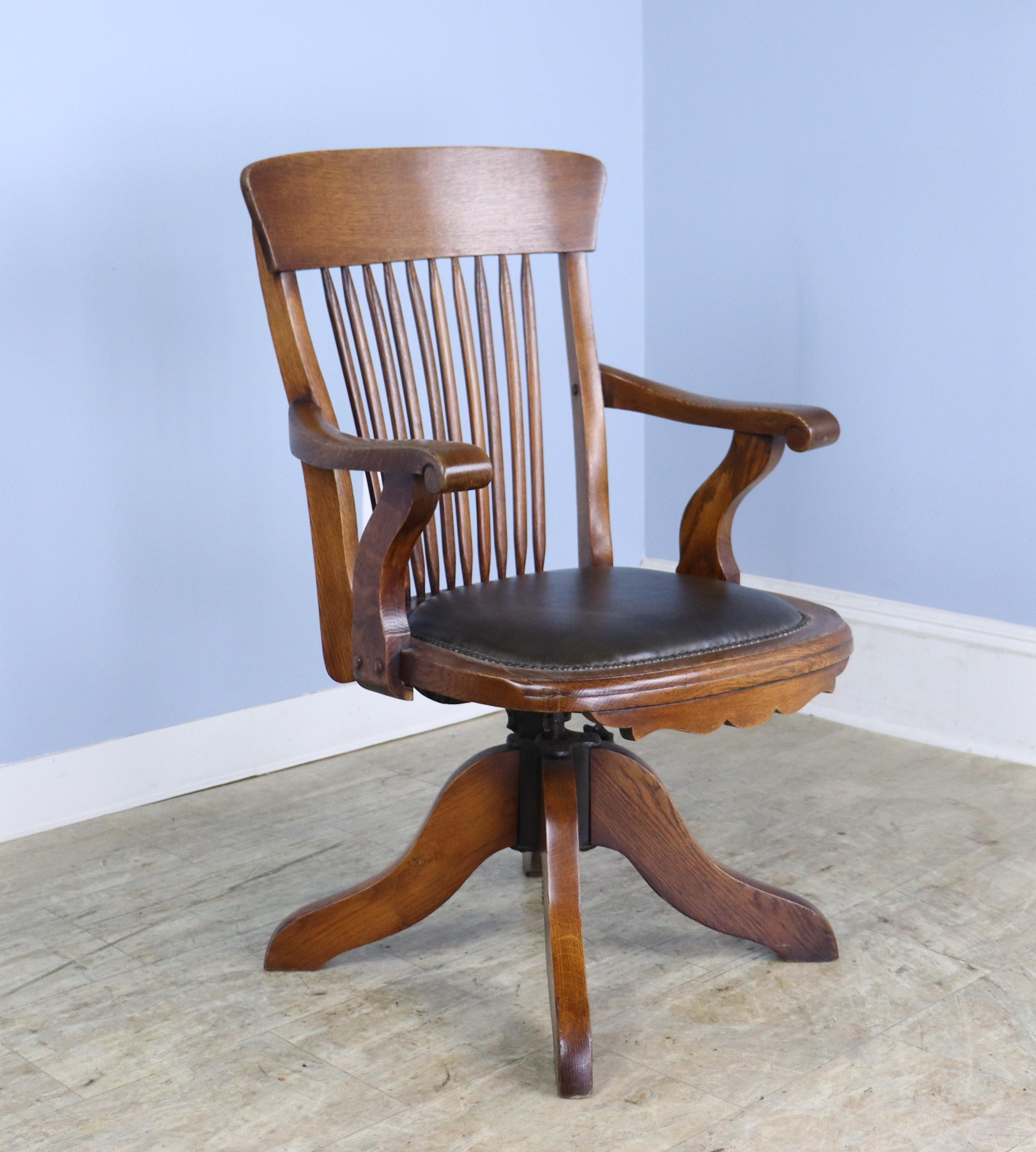 A handsome oak swivelling office chair with a seat height that adjusts manually from 17.5