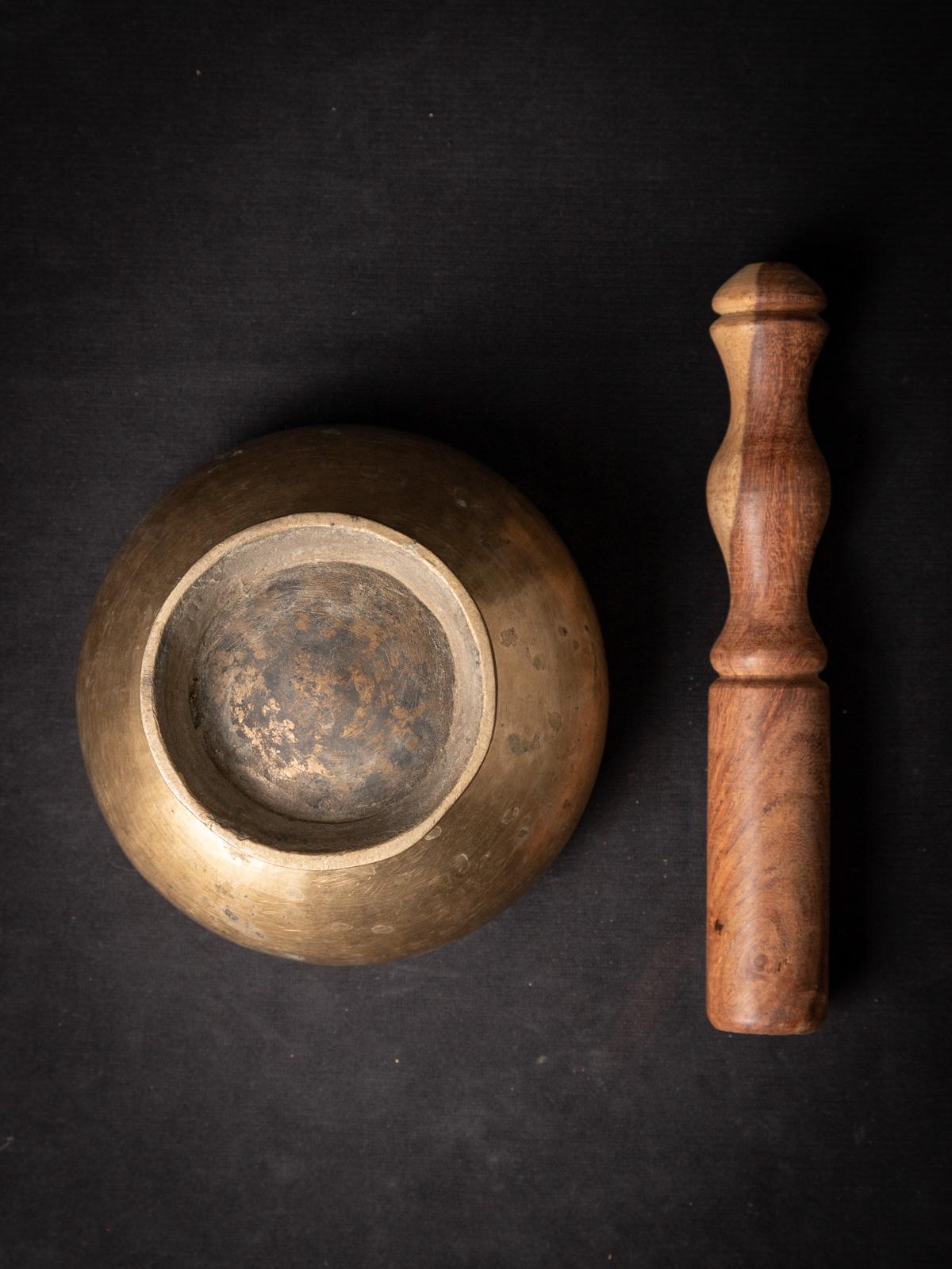 The old bronze Nepali singing bowl is a captivating musical instrument crafted from high-quality bronze. With a height of 8.3 cm and a diameter of 13 cm, this singing bowl emits resonant tones that evoke a sense of tranquility and harmony. Believed