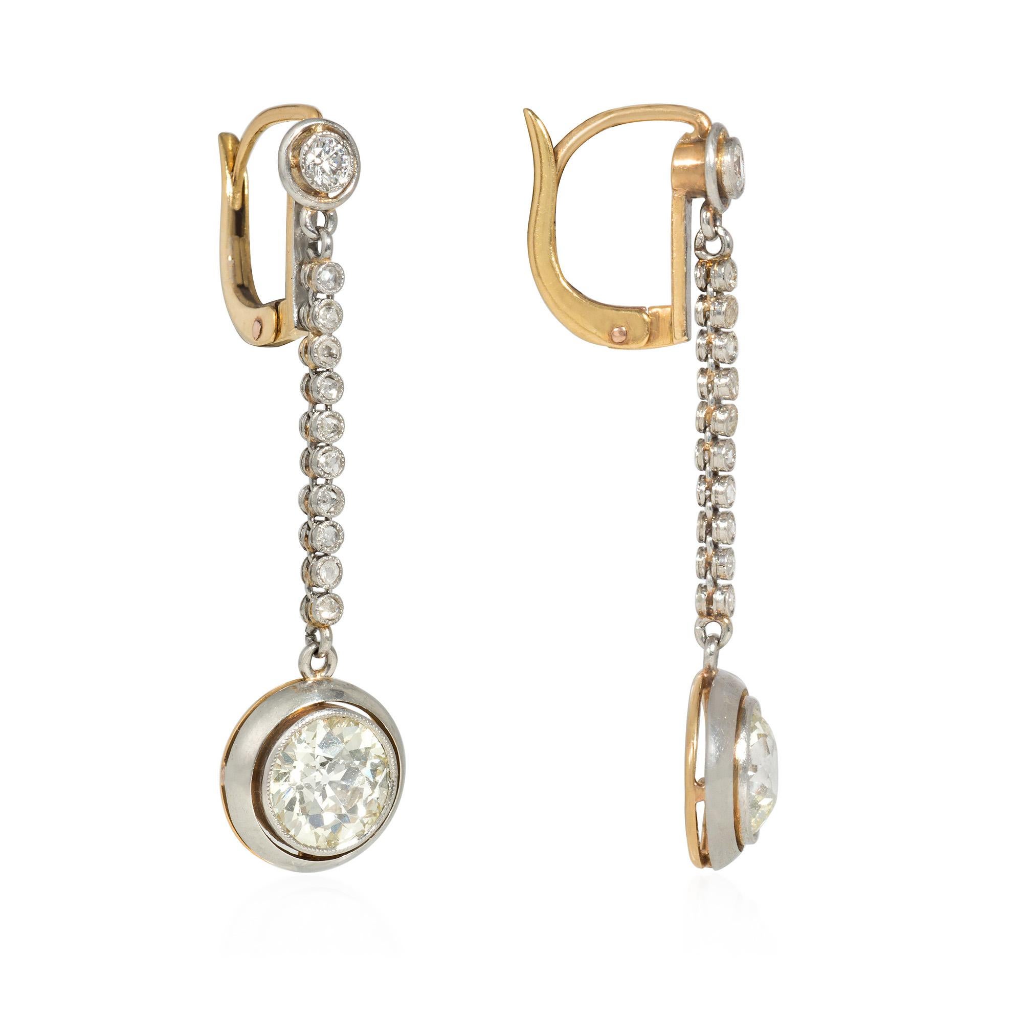 A pair of Edwardian pendant earrings comprised of a line of rose-cut diamonds suspended from a like surmount and terminating in a collet-set old European cut diamond, in platinum and 18k gold. Atw old European cut diamonds 2.61 cts, with two larger
