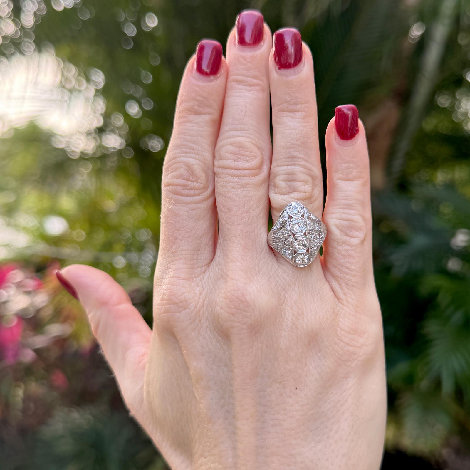 This stunning early 20th-century platinum vintage diamond ring features a timeless design with four Old European Cut diamonds totaling approximately 1.00 carat, elegantly set down the center. Surrounding them are sixteen additional OEC side stones,