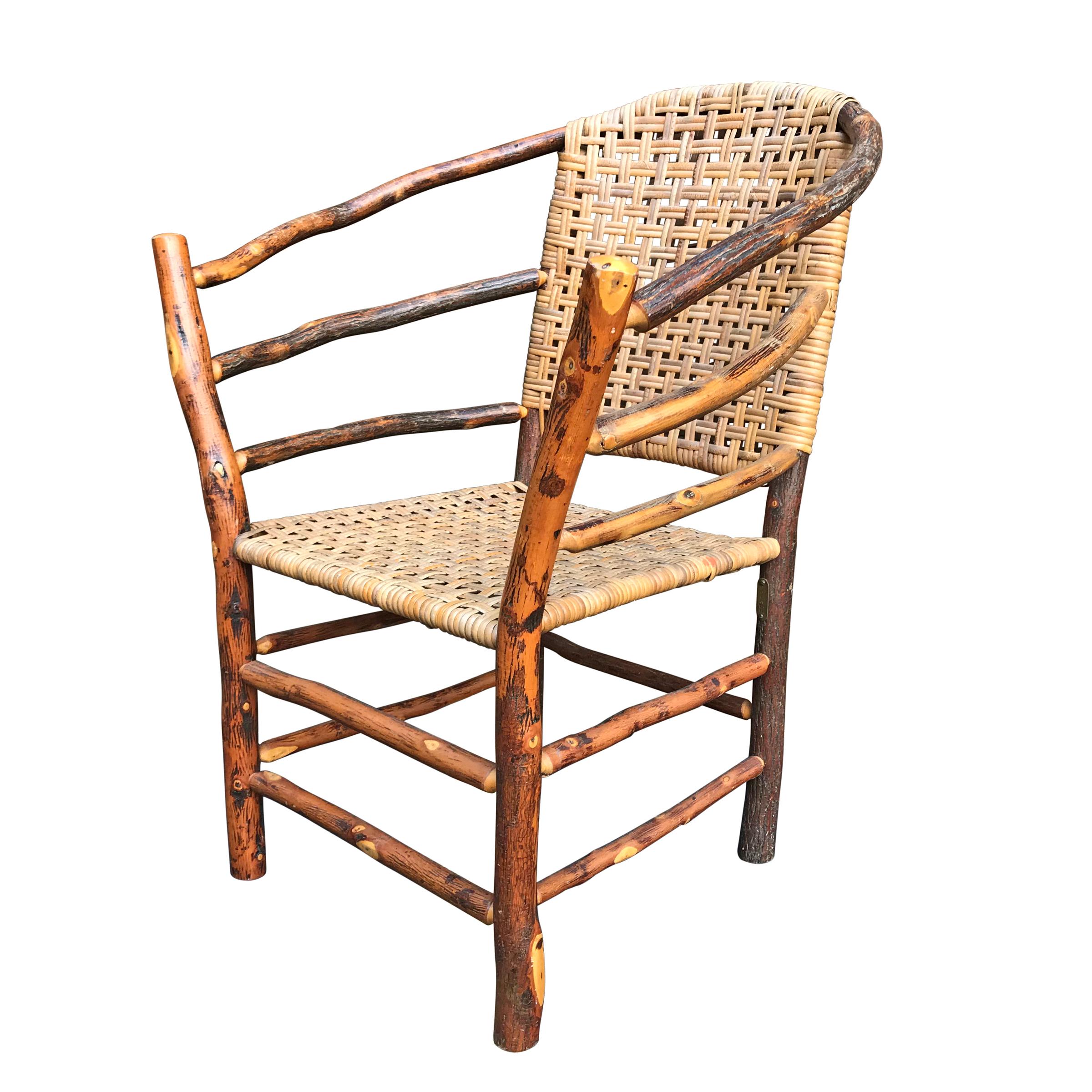 An early 20th century Old Hickory barrel-back armchair constructed of bent hickory sapling arms, legs, and stretchers, and a seat and back of handwoven inner bark strips, also of hickory.