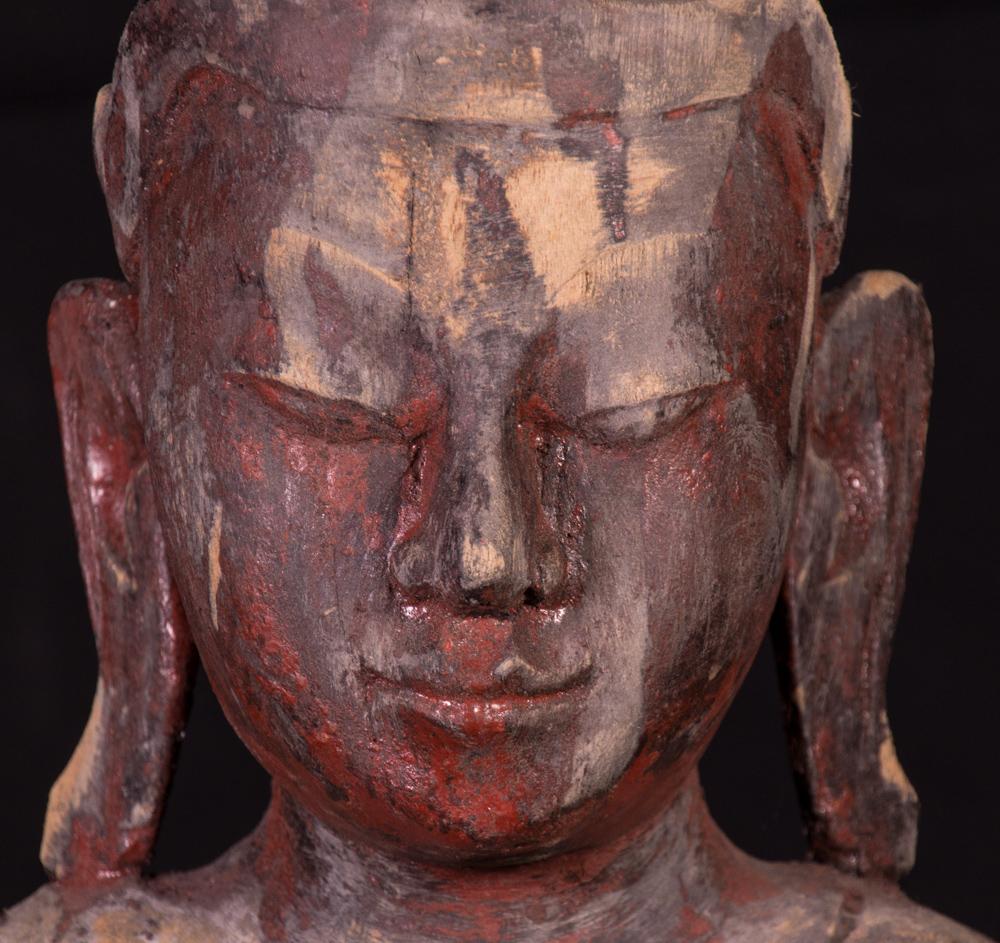 This old wooden Buddha statue is a remarkable piece of art crafted in the Mandalay style from Burma (Myanmar), dating back to the early 20th century. Standing 94 cm high, 29 cm wide, and 14 cm deep, this finely carved wooden sculpture captures the