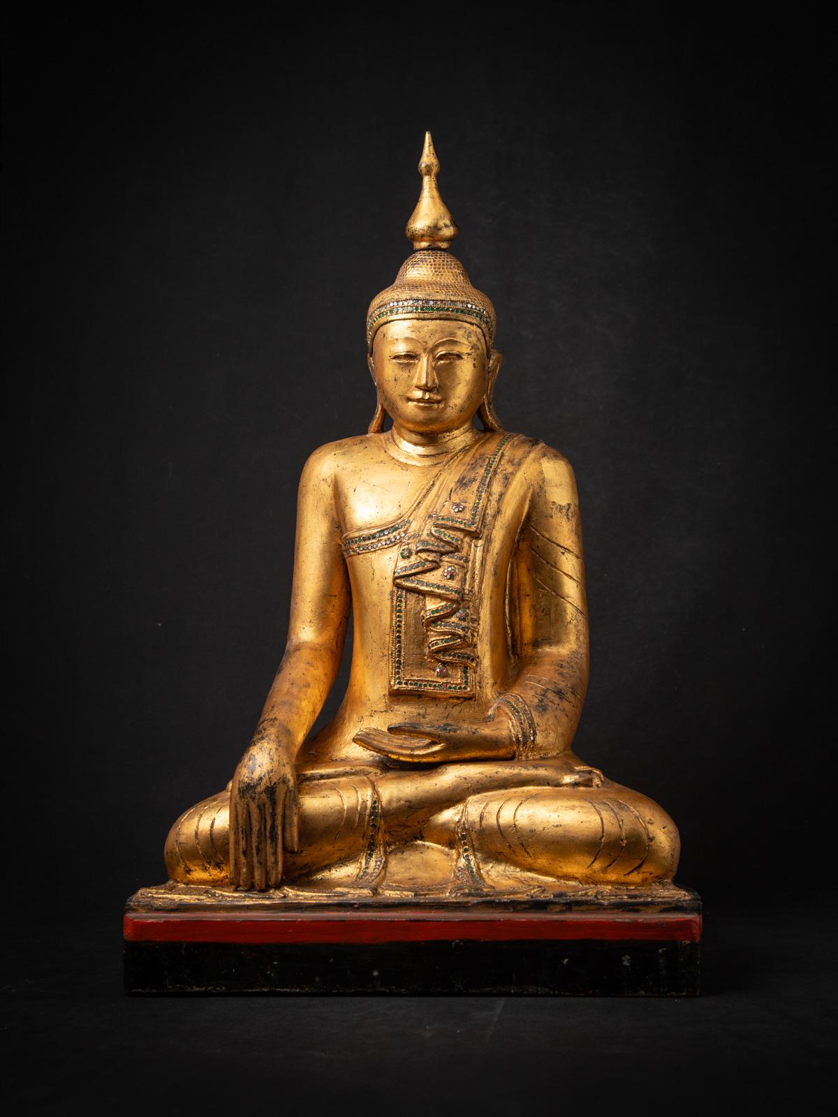Cette ancienne statue de Bouddha birmane en bois est un magnifique exemple de l'artisanat du début du XXe siècle dans le style Amarapura. Sculptée dans du bois massif et magnifiquement dorée à l'or fin 24 carats, la statue mesure 78 cm de haut, 48,5