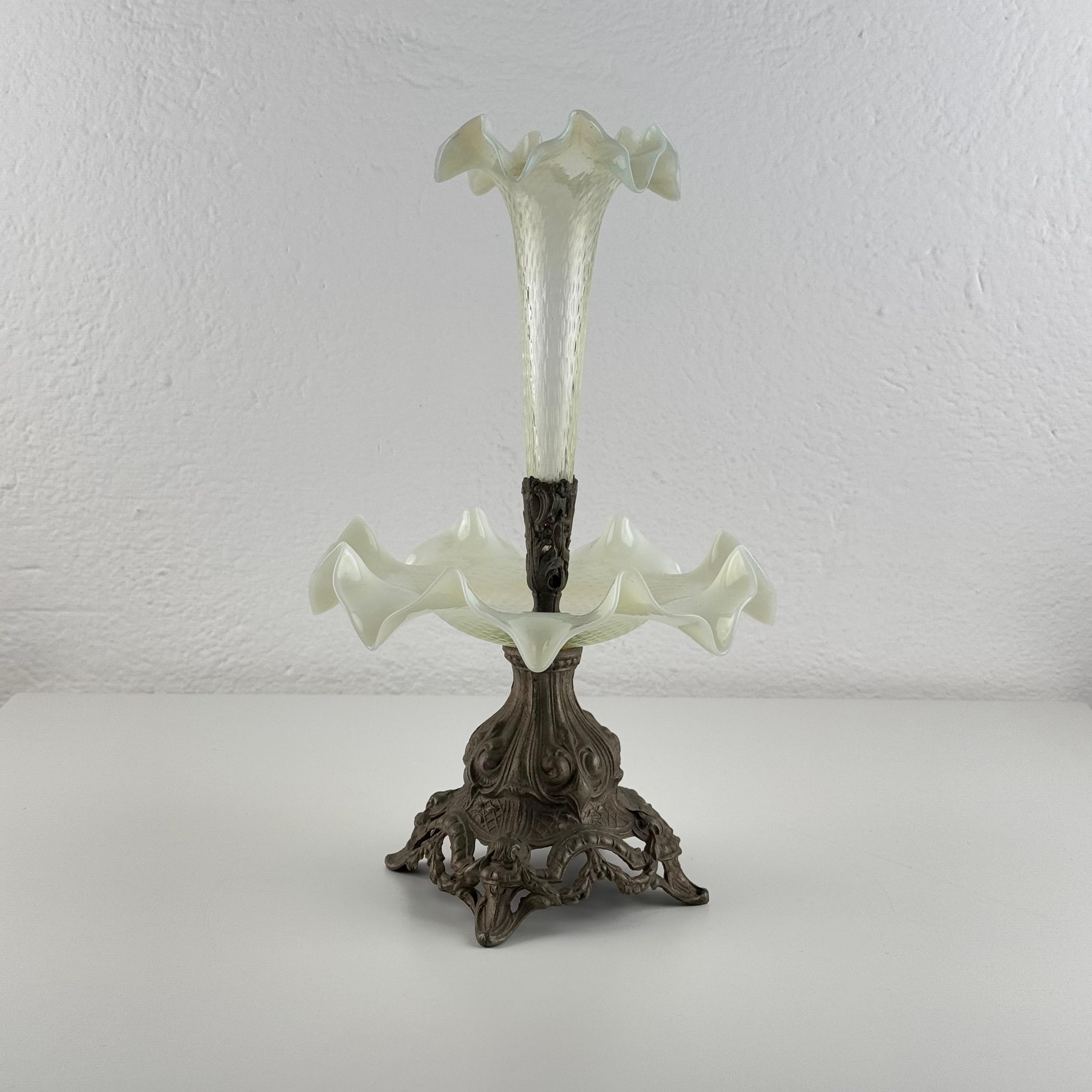 A charming and beautifully preserved Art Nouveau epergne, combining delicate opalescent glass with an intricately cast metal base. This poetic object captures the refined decorative sensibility of the early 1900s, when table décor blended elegance