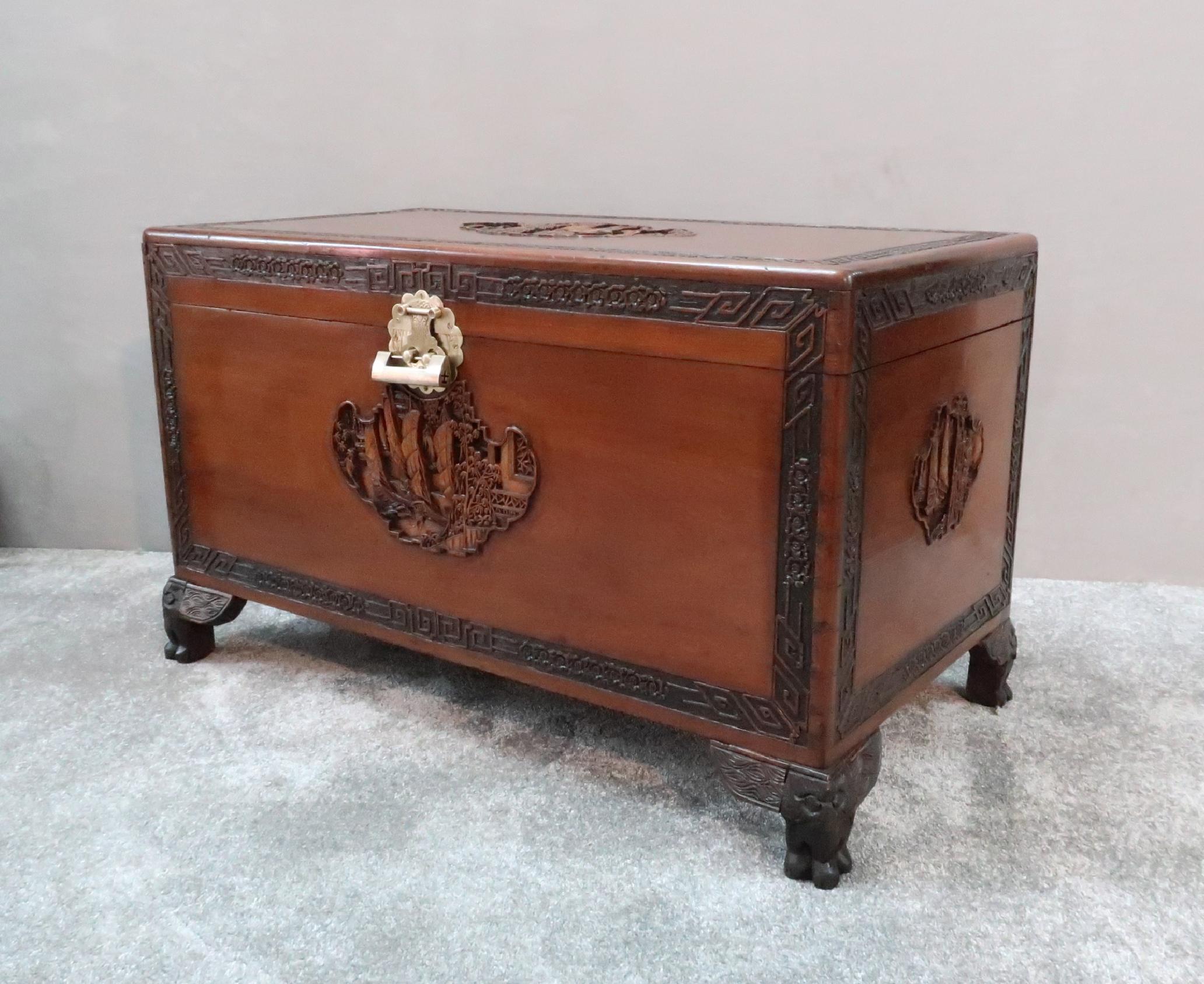 An extremely good quality early 20th century oriental freestanding teak chest with beautifully carved inset panels of sailing ships, pagodas and trees to all four sides and top with floral border stood on cabriole feet. The chest retains its