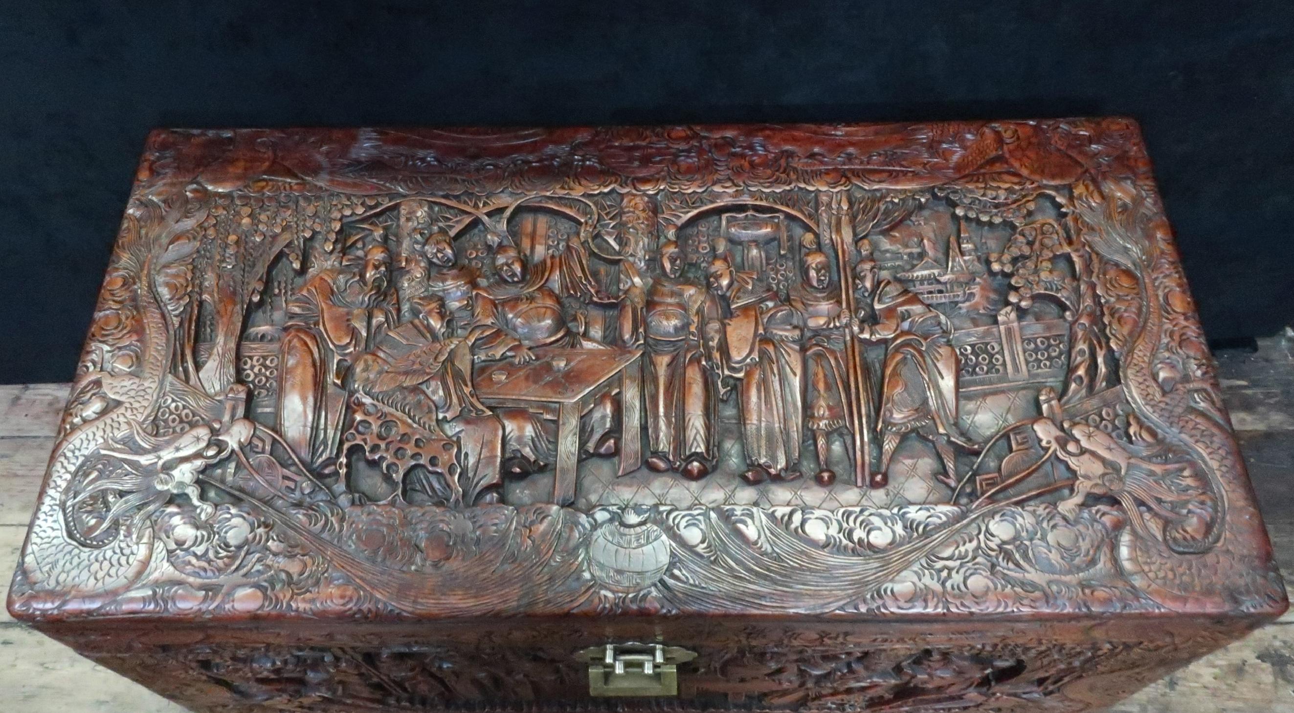 An extremely good quality early 20th century oriental freestanding camphor wood chest profusely and deeply carved with scenes of the eight immortals, dragons, birds, pagodas and trees. The sides and back are carved with mountain scenes within a